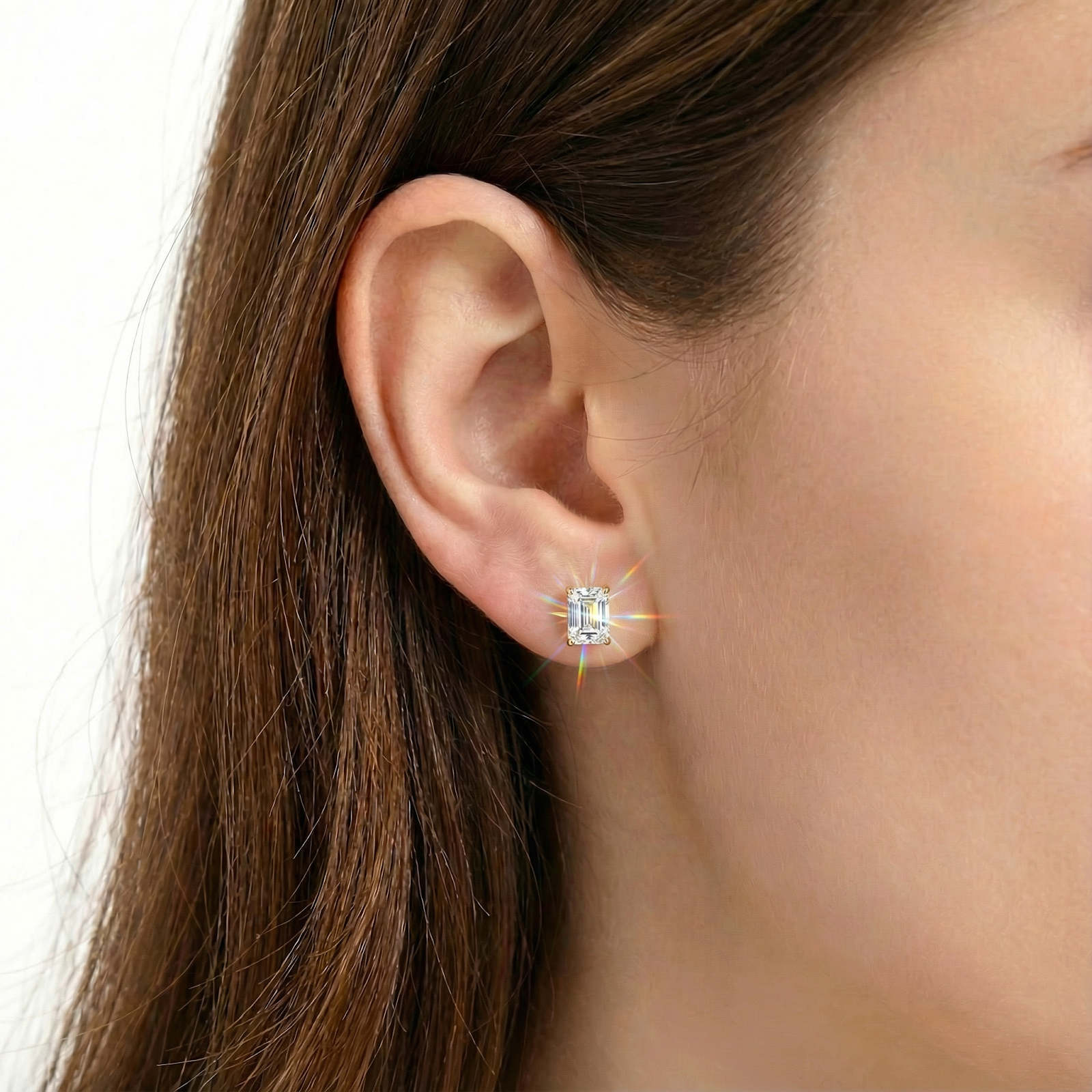 Woman wearing a baguette cut simulated diamond stud earring in 18K gold vermeil on her earlobe.