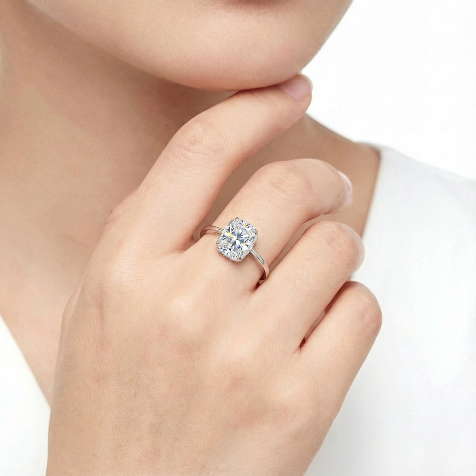 Model wearing the Marcella emerald-cut moissanite ring in sterling silver on her ring finger.