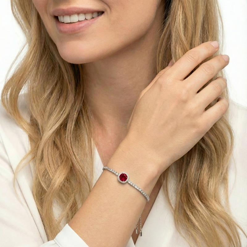 Woman wearing the sterling silver cushion-cut simulated ruby halo bracelet on her wrist.