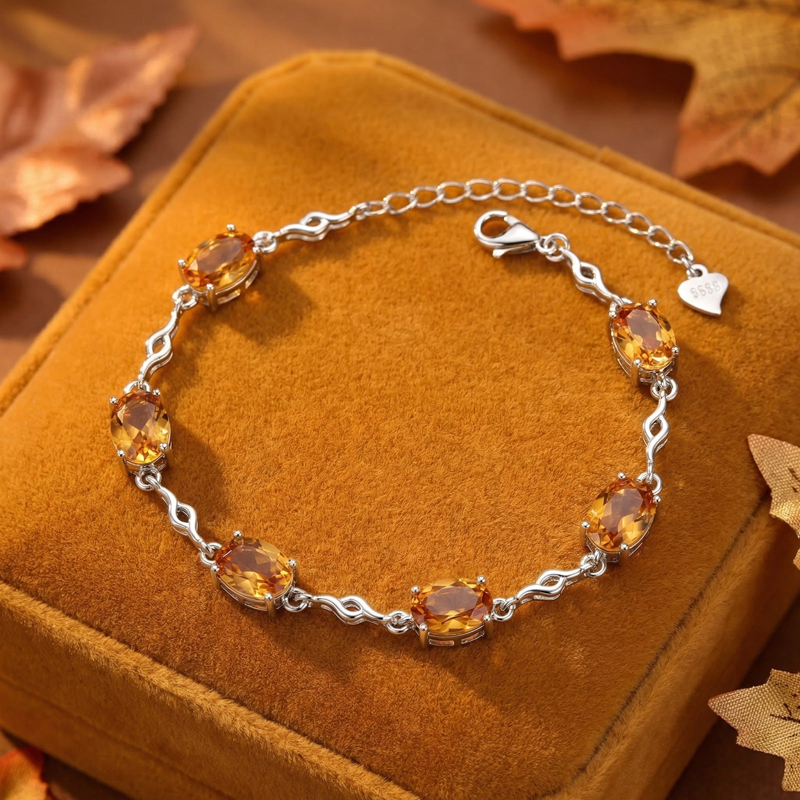 Sterling silver bracelet with five oval-cut simulated topaz stones on a brown velvet box with autumn leaves.