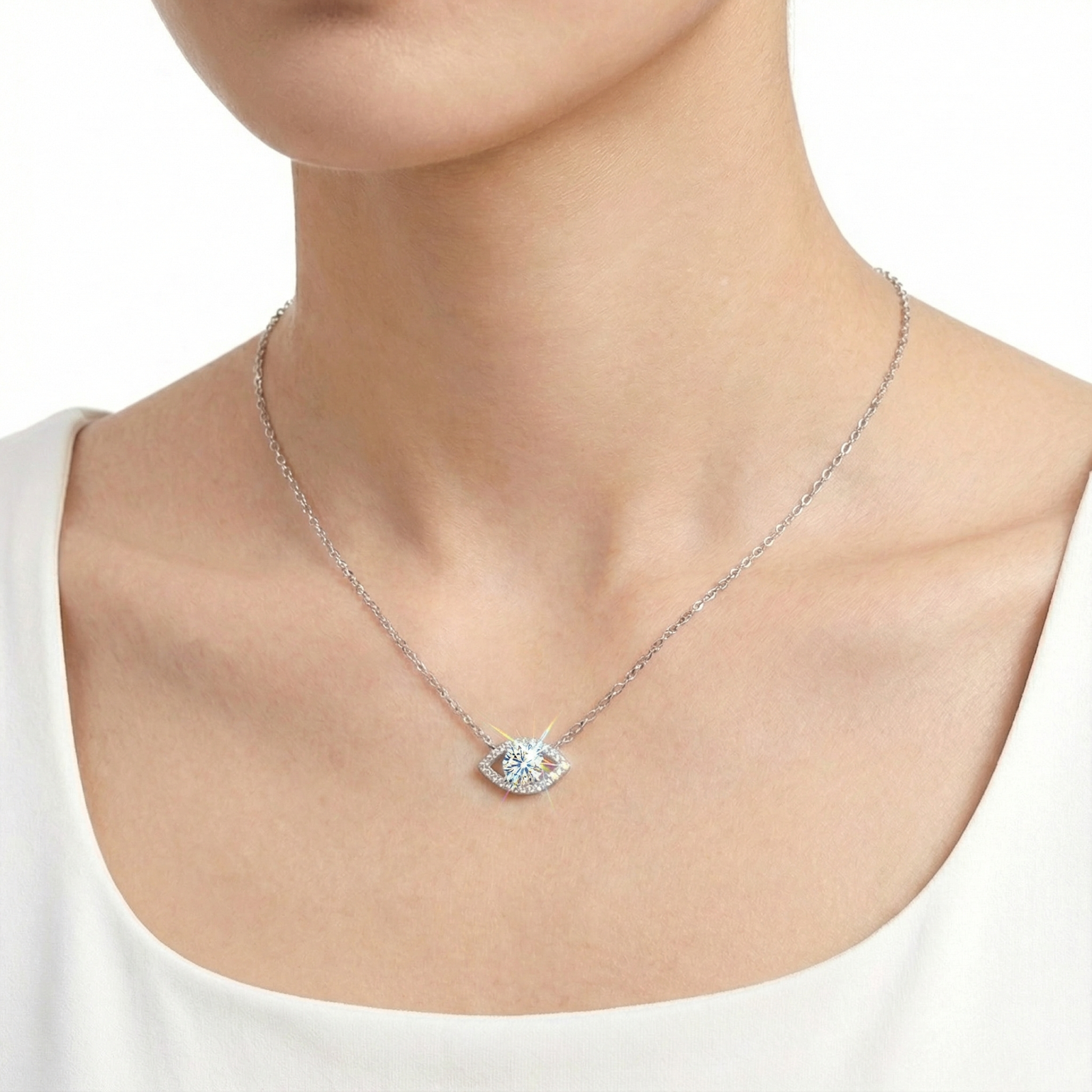 Model wearing the silver Lyraea Eye necklace featuring a brilliant round cut moissanite pendant.