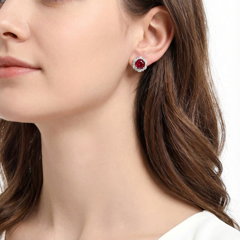 Side profile of a woman wearing the Rubienne simulated ruby halo stud earring in silver.
