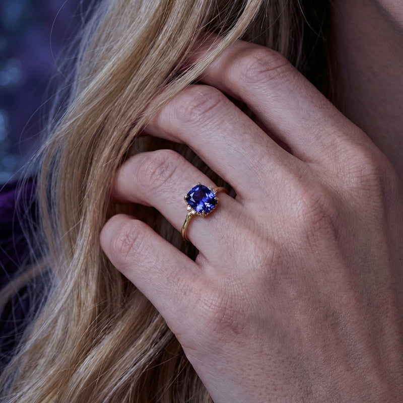 Woman wearing the Vesperine cushion cut simulated tanzanite ring in 18K gold vermeil on her ring finger.