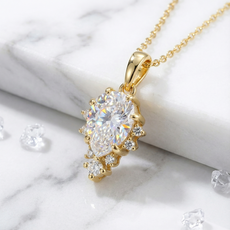 Macro detail of the pear-cut zirconia pendant and 18K gold vermeil setting on a marble surface.