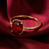 Cushion-cut simulated ruby ring in 18K gold vermeil displayed on red silk fabric.