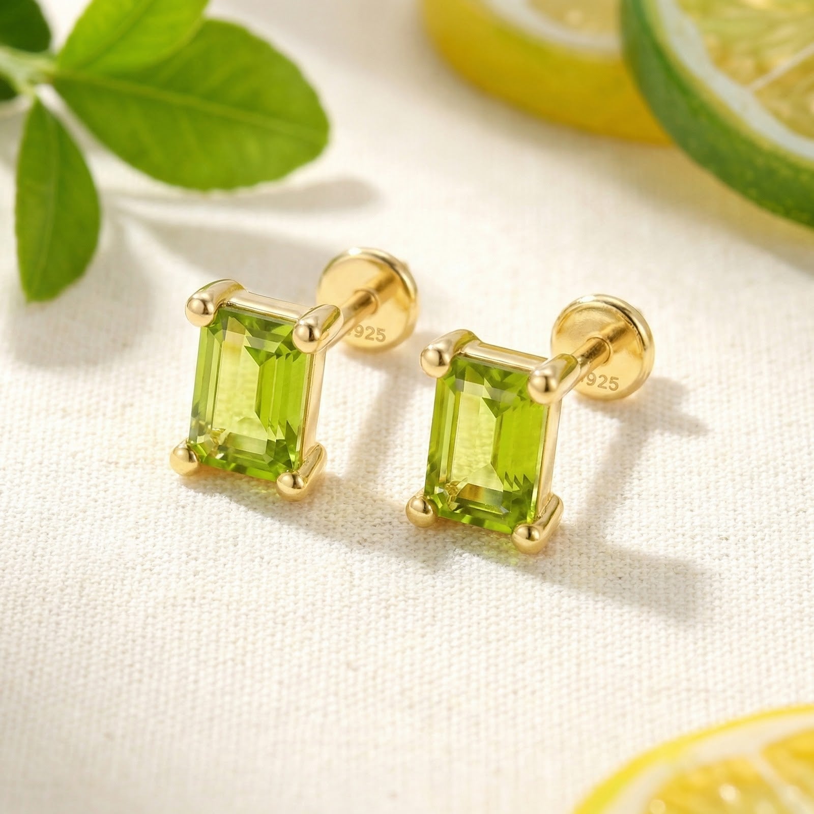 Close-up of emerald cut simulated peridot earrings in 18K gold vermeil showing the S925 hallmark and setting.