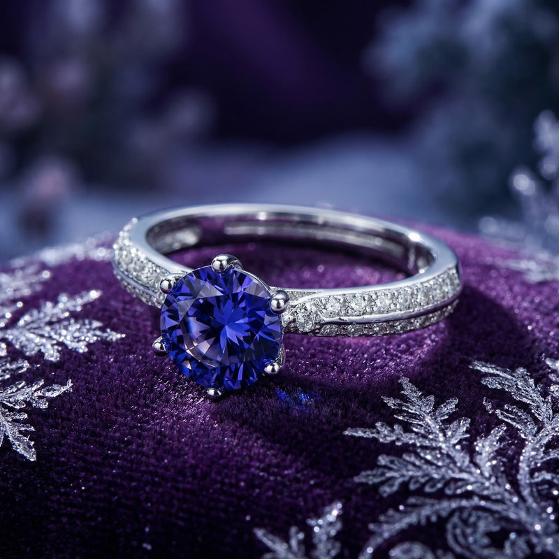 Macro view of a round simulated tanzanite ring in sterling silver showing milgrain setting and side stones.