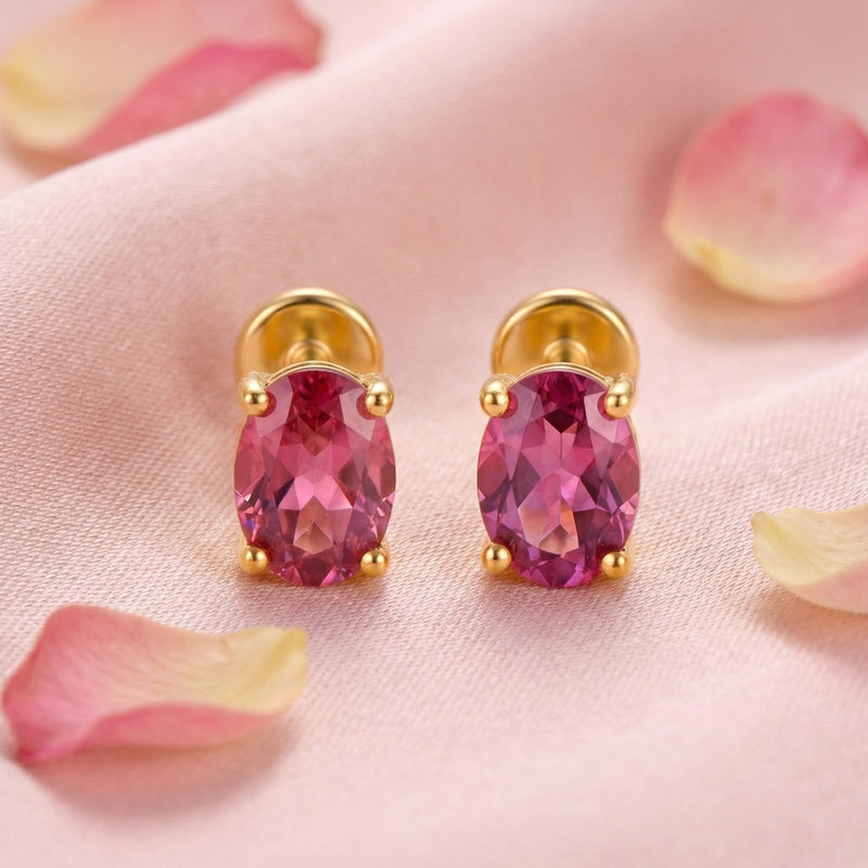 Front view of oval-cut simulated pink tourmaline stud earrings in 18K gold vermeil on a pink petal background.
