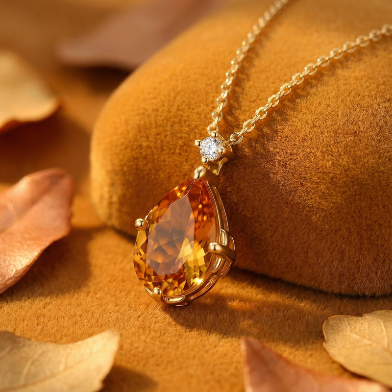 Macro view of a pear-cut simulated topaz pendant in 18K gold vermeil showing the honeyed amber facets.