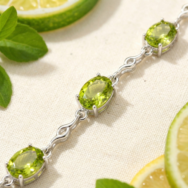 Macro view of oval cut simulated peridot stones and sterling silver links on the Perisienne bracelet.
