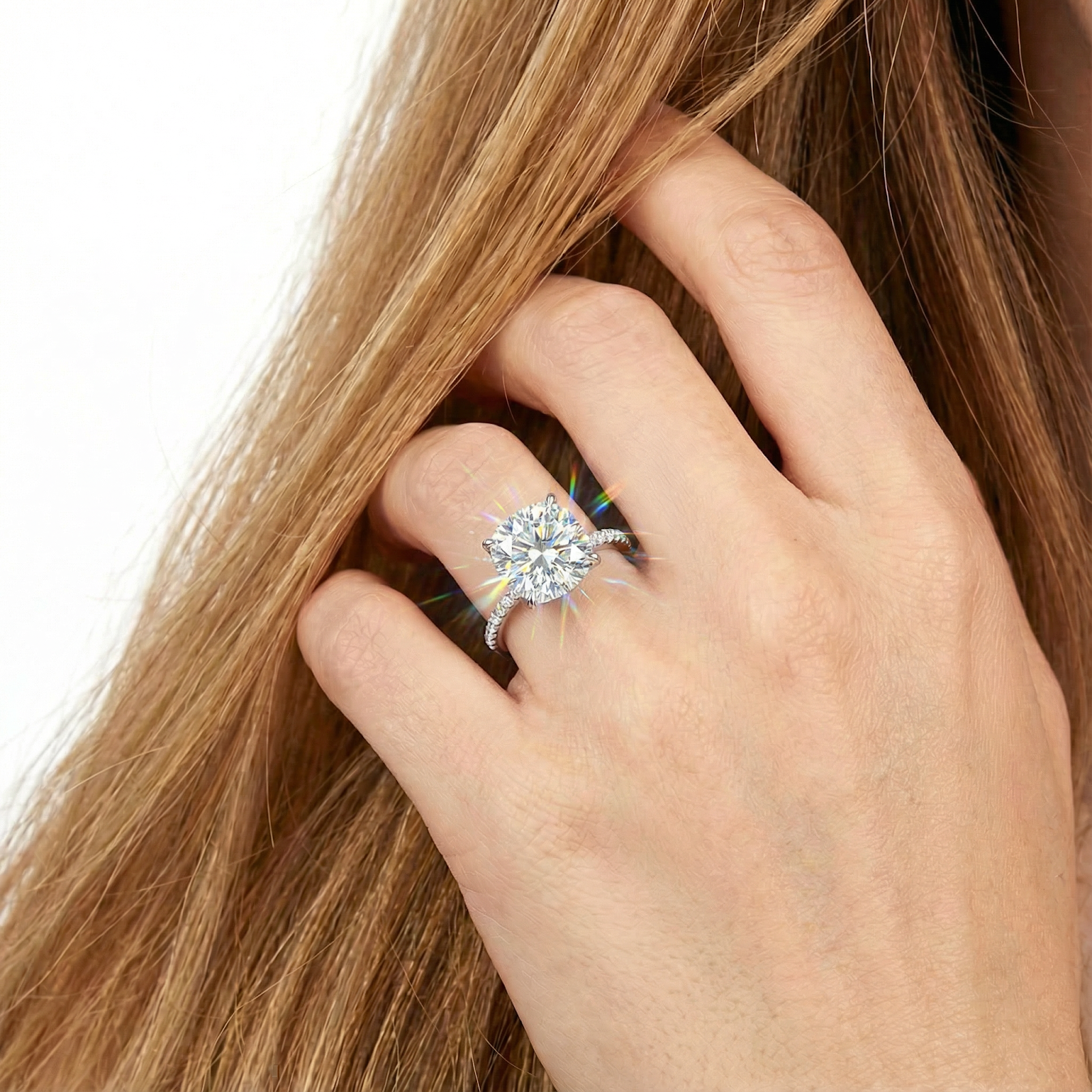 Close-up of the 10x10mm cushion cut simulated diamond ring on a finger, showing its brilliant fire.