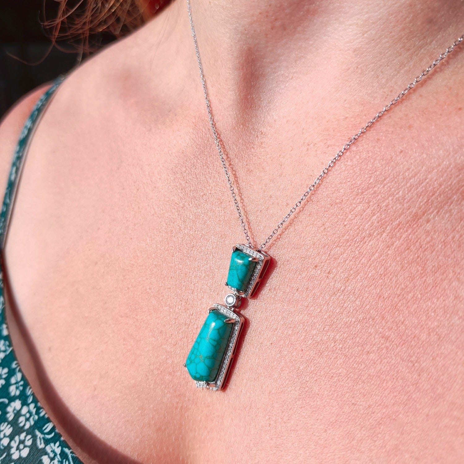 Turquoise Seabed Jewel Necklace featuring a turquoise pendant in a sterling silver setting on a model in sunlight