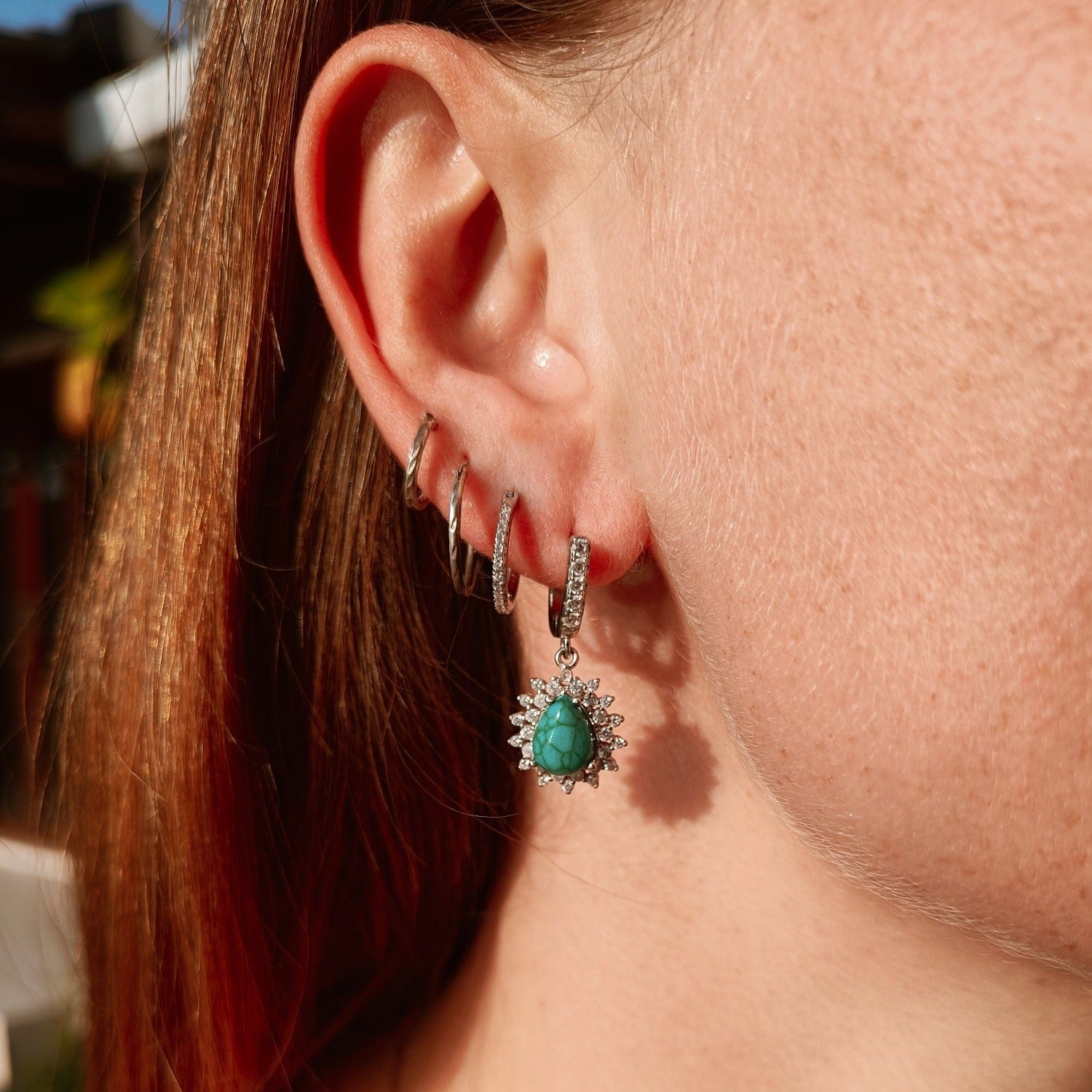 Blue Lagoon Turquoise Earrings featuring turquoise stones set in S925 sterling silver on a model in natural shaded lighting