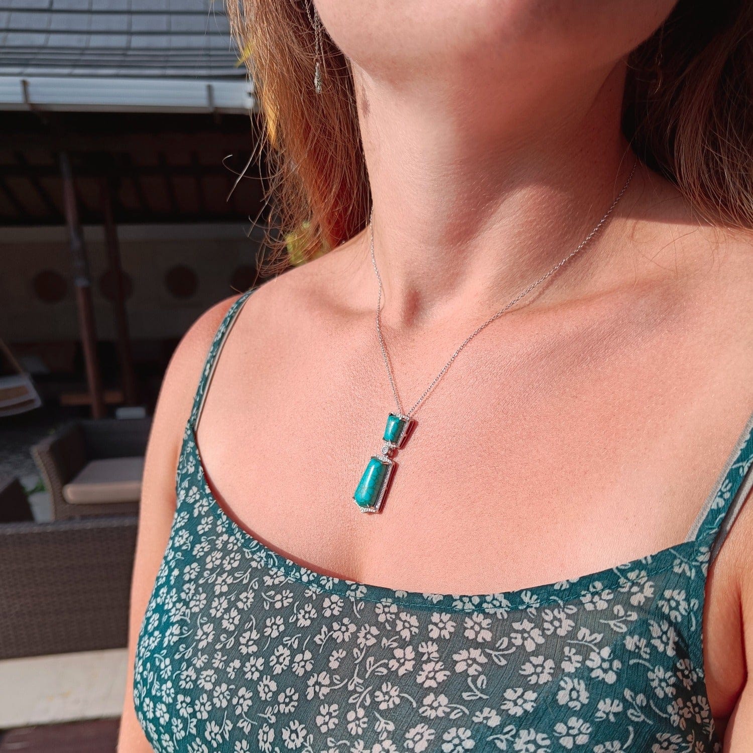 Turquoise Seabed Jewel Necklace featuring a turquoise pendant in a sterling silver setting zoomed out view on a model in natural sunlight