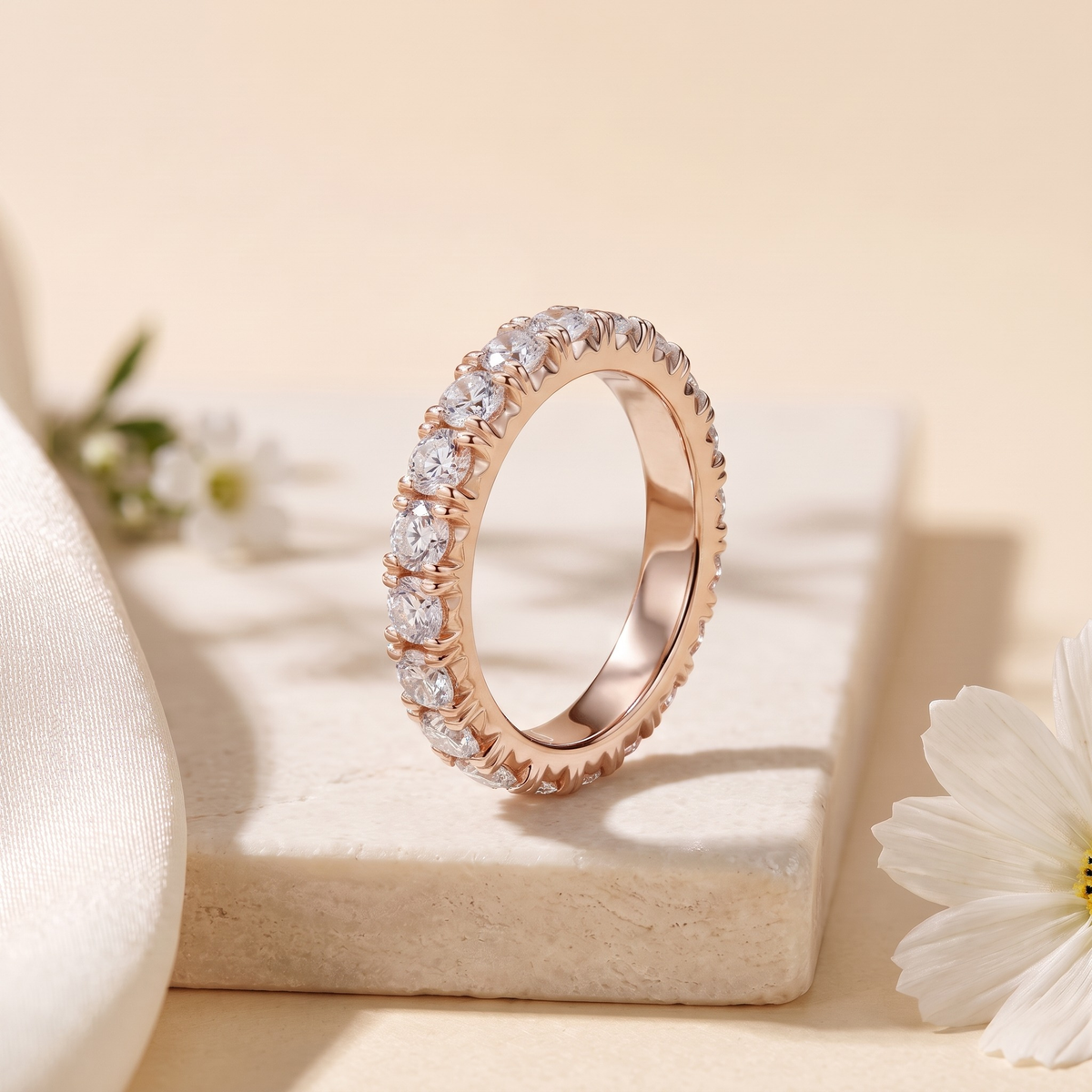 Round moissanite eternity band in rose gold, upright product view.