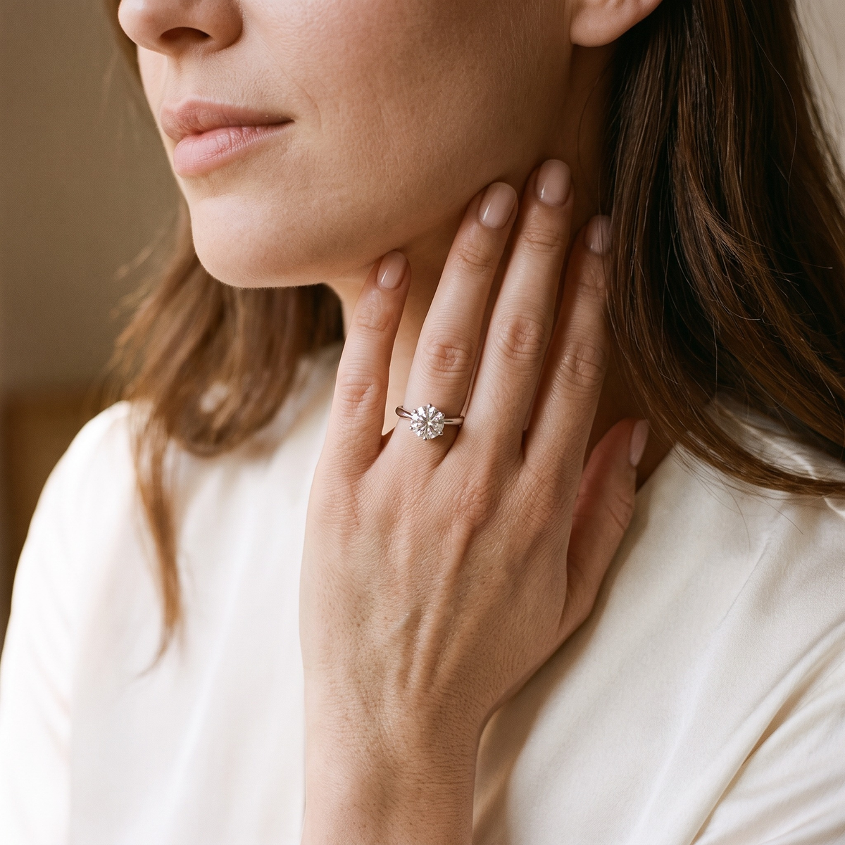 Silver 3CT round moissanite solitaire worn by a model, portrait detail
