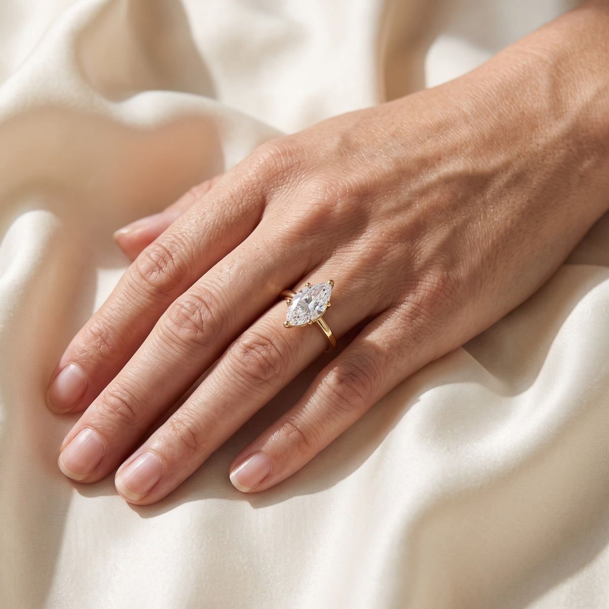 Yellow gold marquise moissanite solitaire worn on a model hand