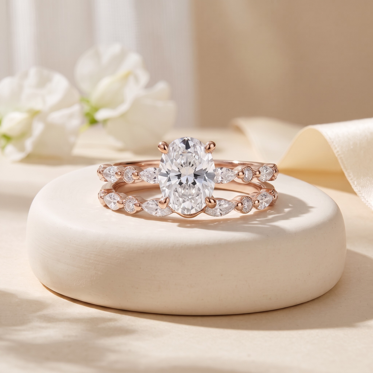 Oval moissanite two-piece ring set in rose gold, isolated front view