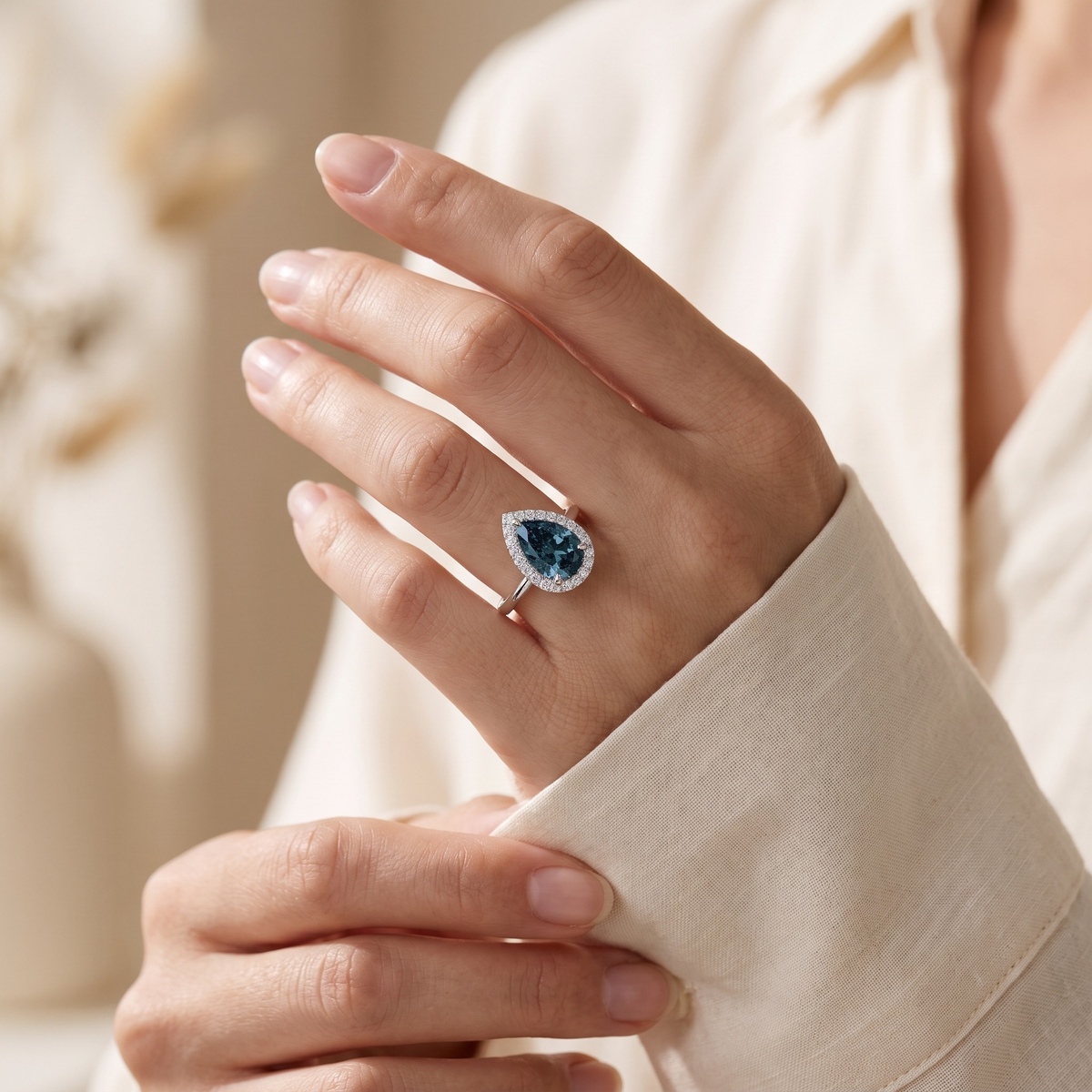 The Karina silver pear-cut halo ring worn by a model, cuff detail