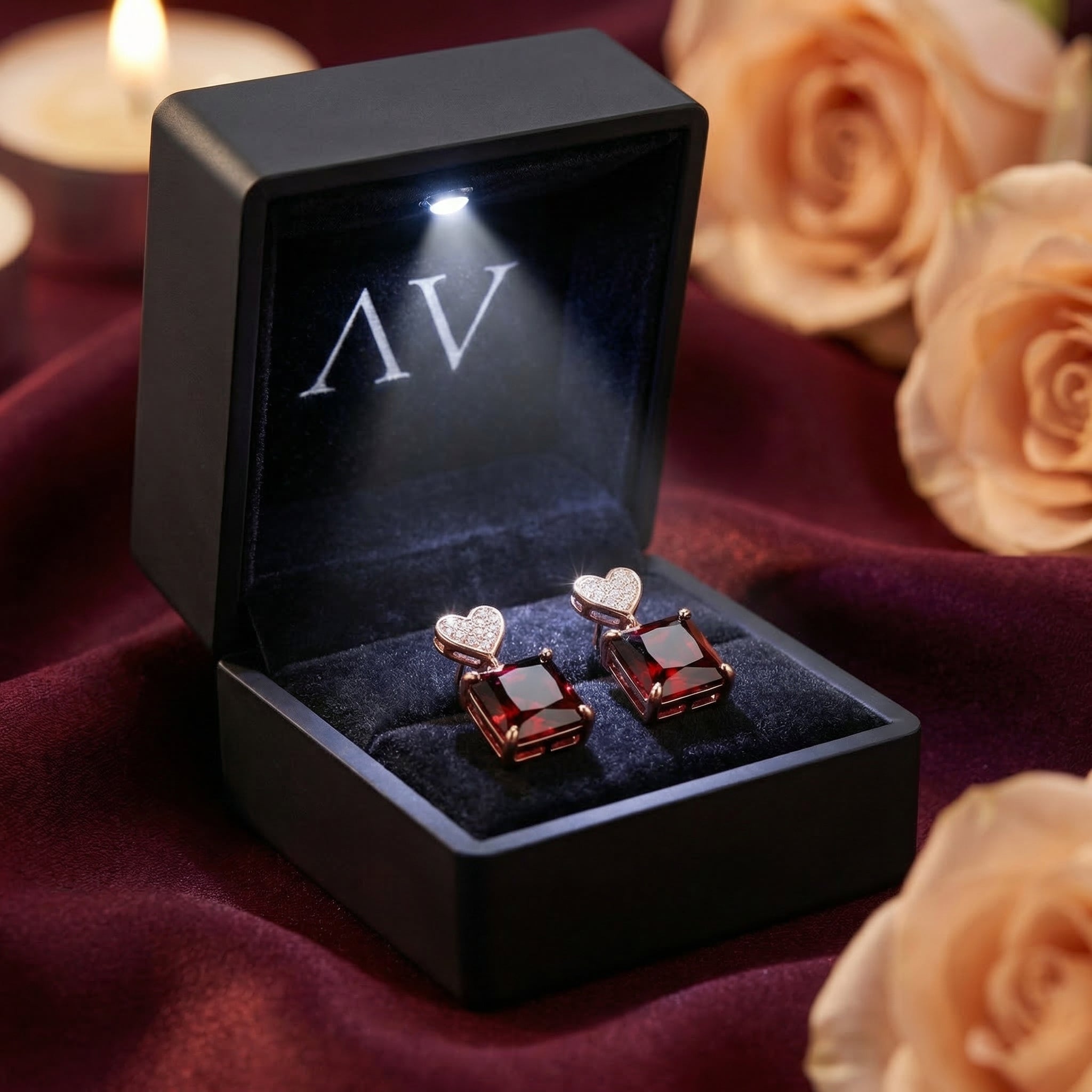 Serafina red garnet and rose gold earrings presented in a black LED-lighted jewelry box with roses.