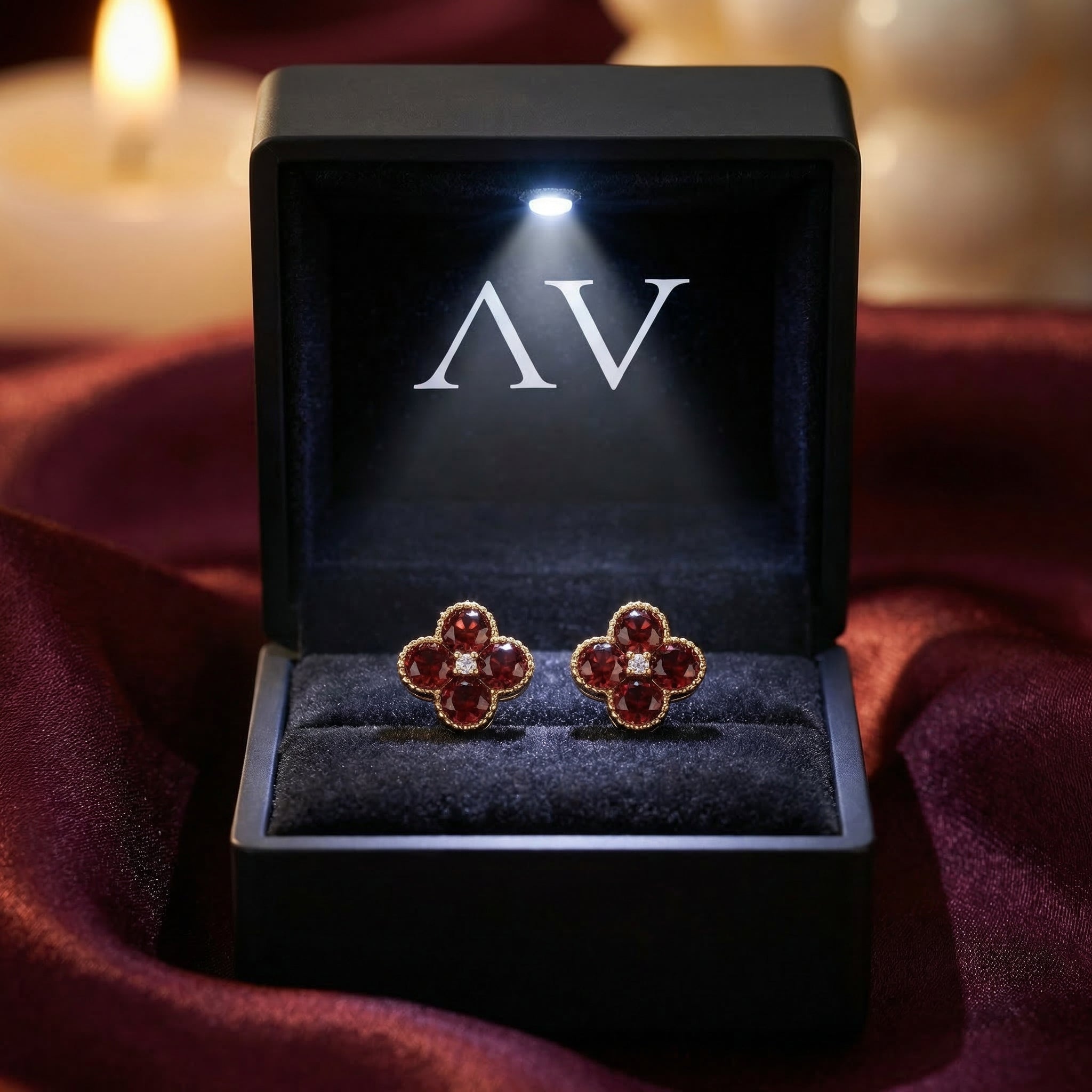 Ambrosia garnet floral stud earrings presented in a lighted black jewelry box with the AV logo.