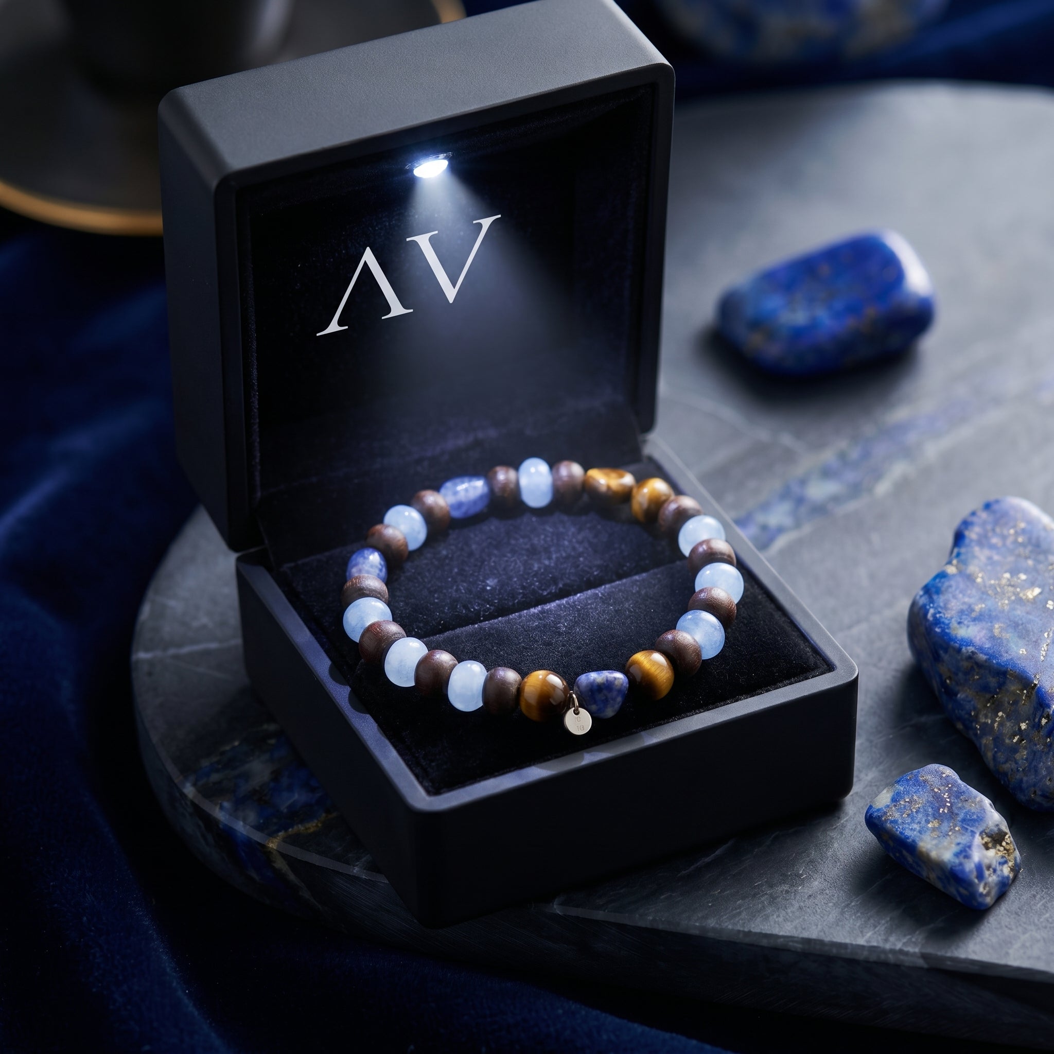 The Stargazer Natural Lapis Bracelet with round lapis and tiger's eye beads and gold plated charm in an LED gift box.