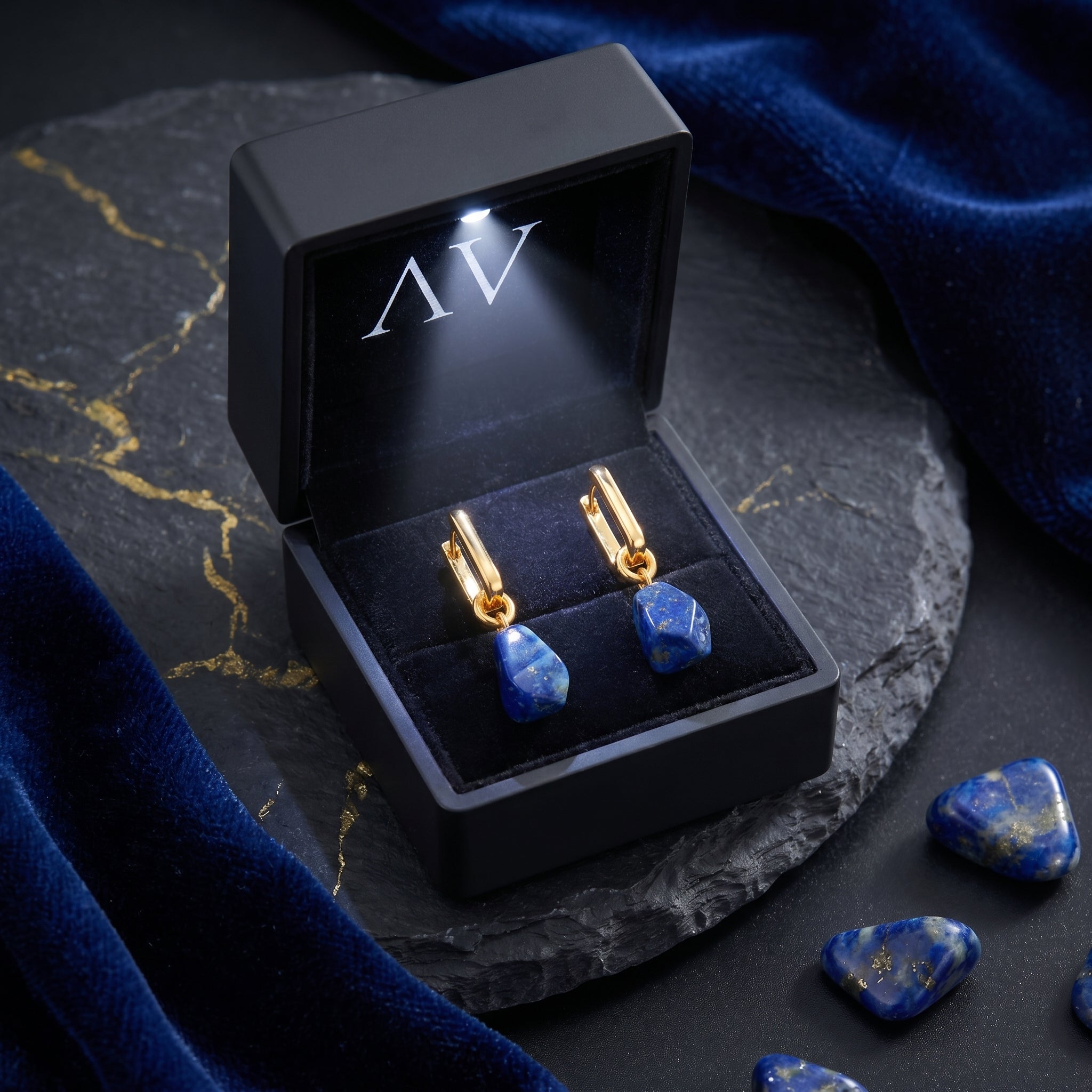 The Cybele gold-plated lapis lazuli earrings displayed in a premium black LED-lighted gift box.