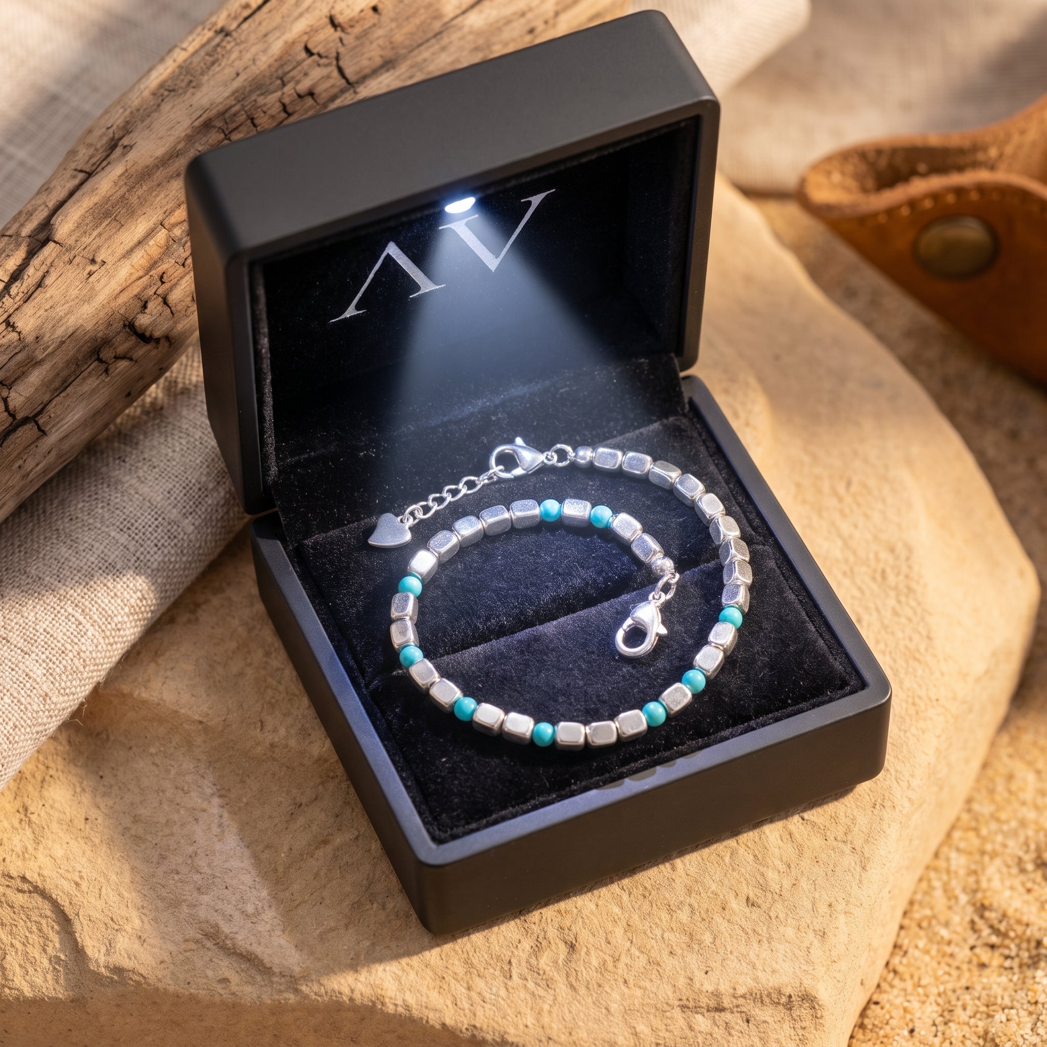 Silver and turquoise bead bracelet presented in a black LED-lit jewelry box.