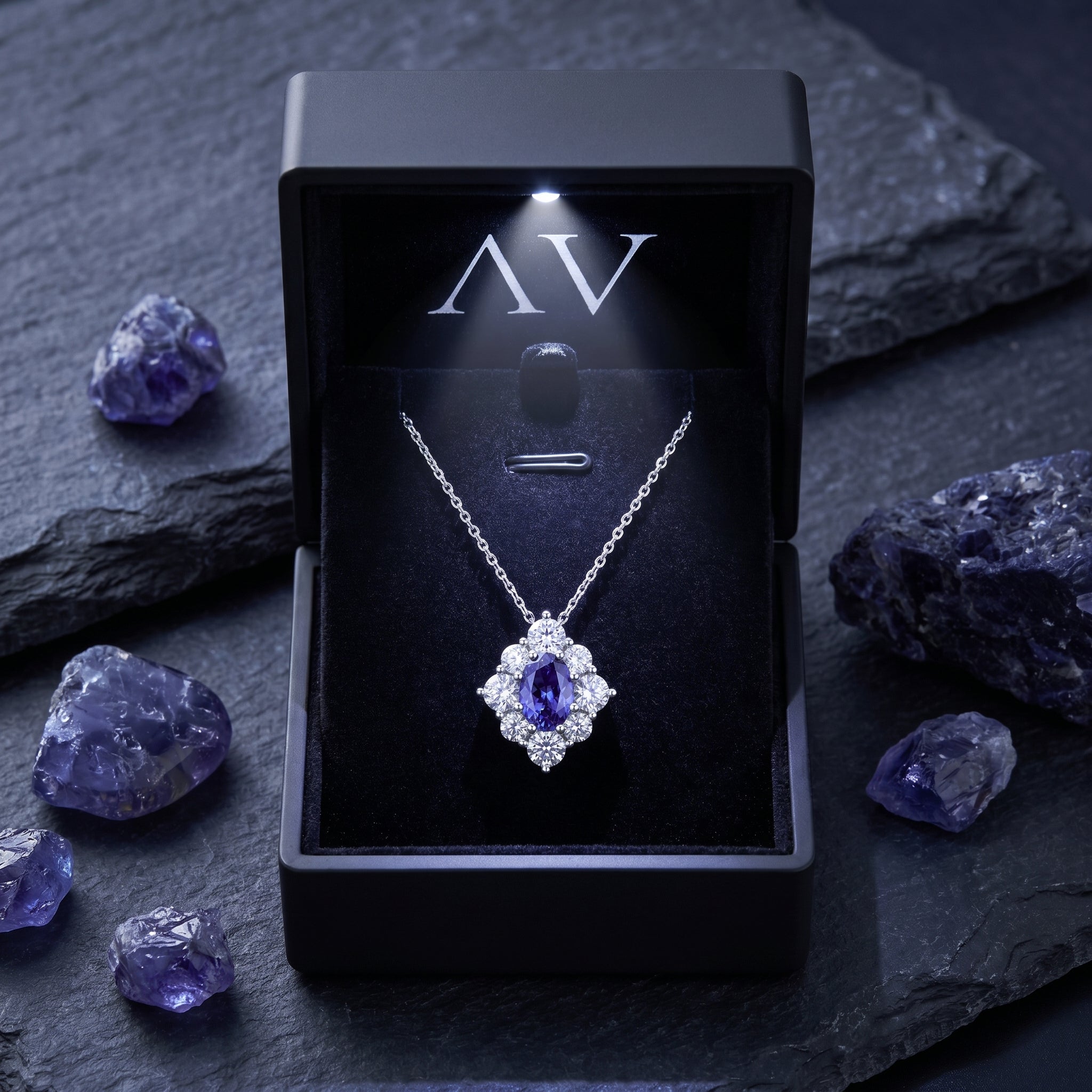 Natural tanzanite halo necklace presented in a black LED-lit gift box with raw gemstone accents.
