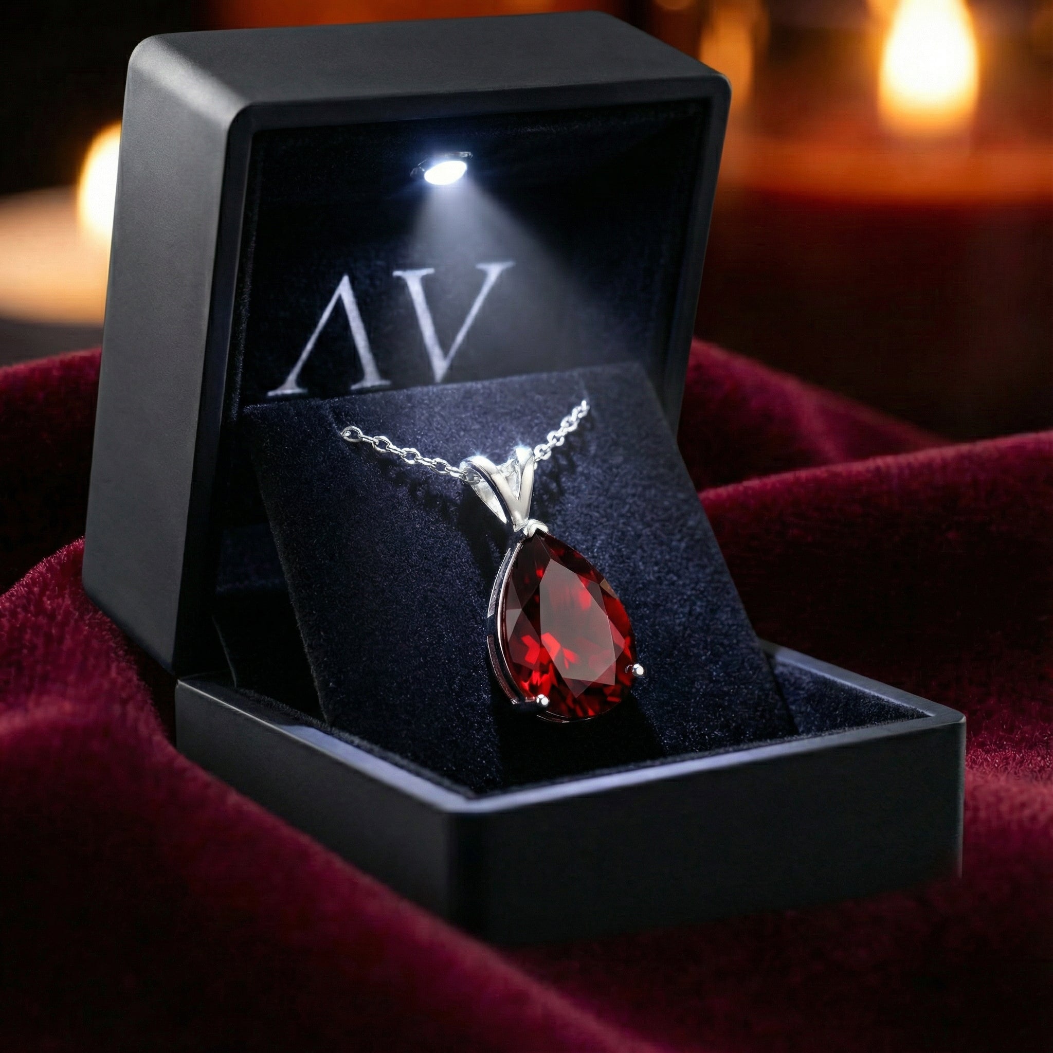 Pear cut simulated garnet sterling silver necklace inside a black LED-lighted jewelry presentation box.