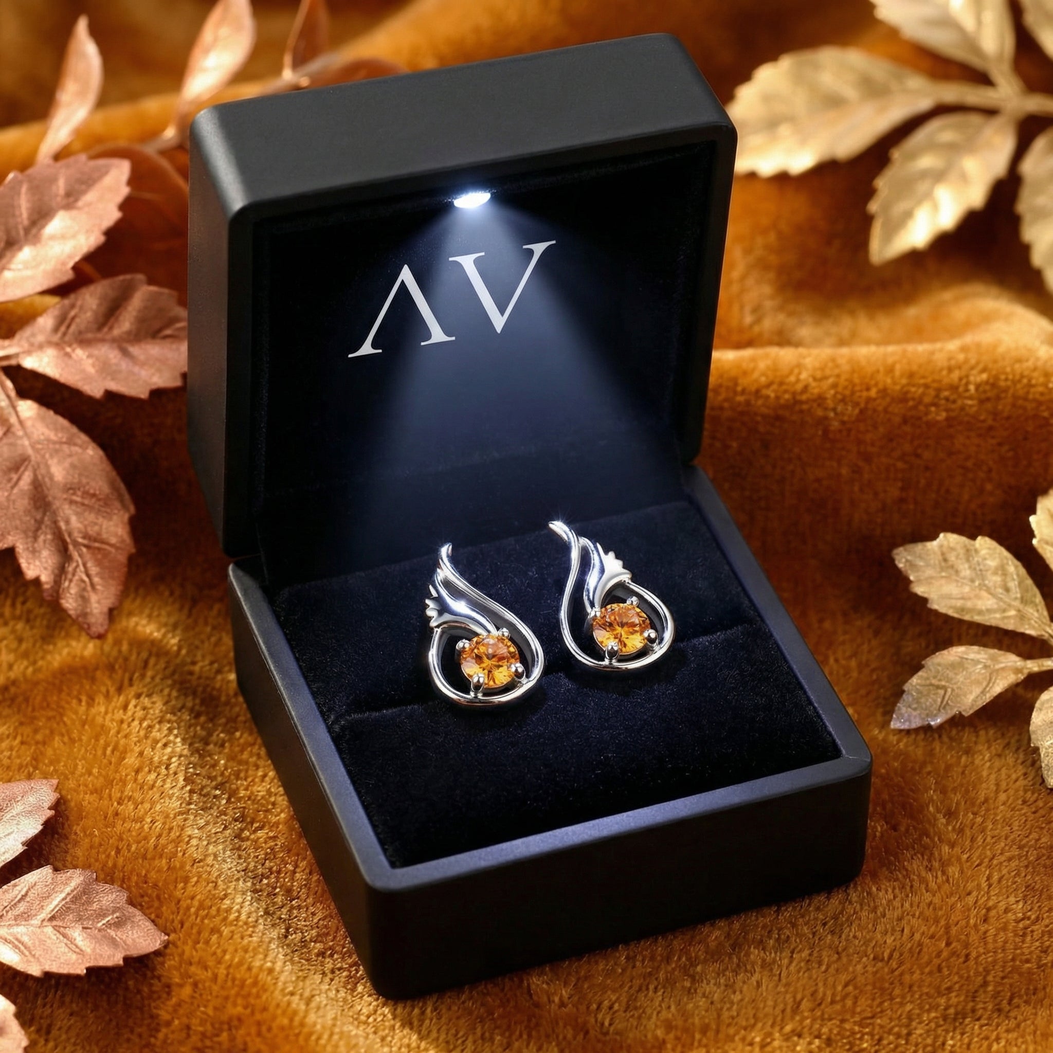 Melisara Bud sterling silver earrings with round-cut simulated topaz stones inside a black LED-lit jewelry gift box.