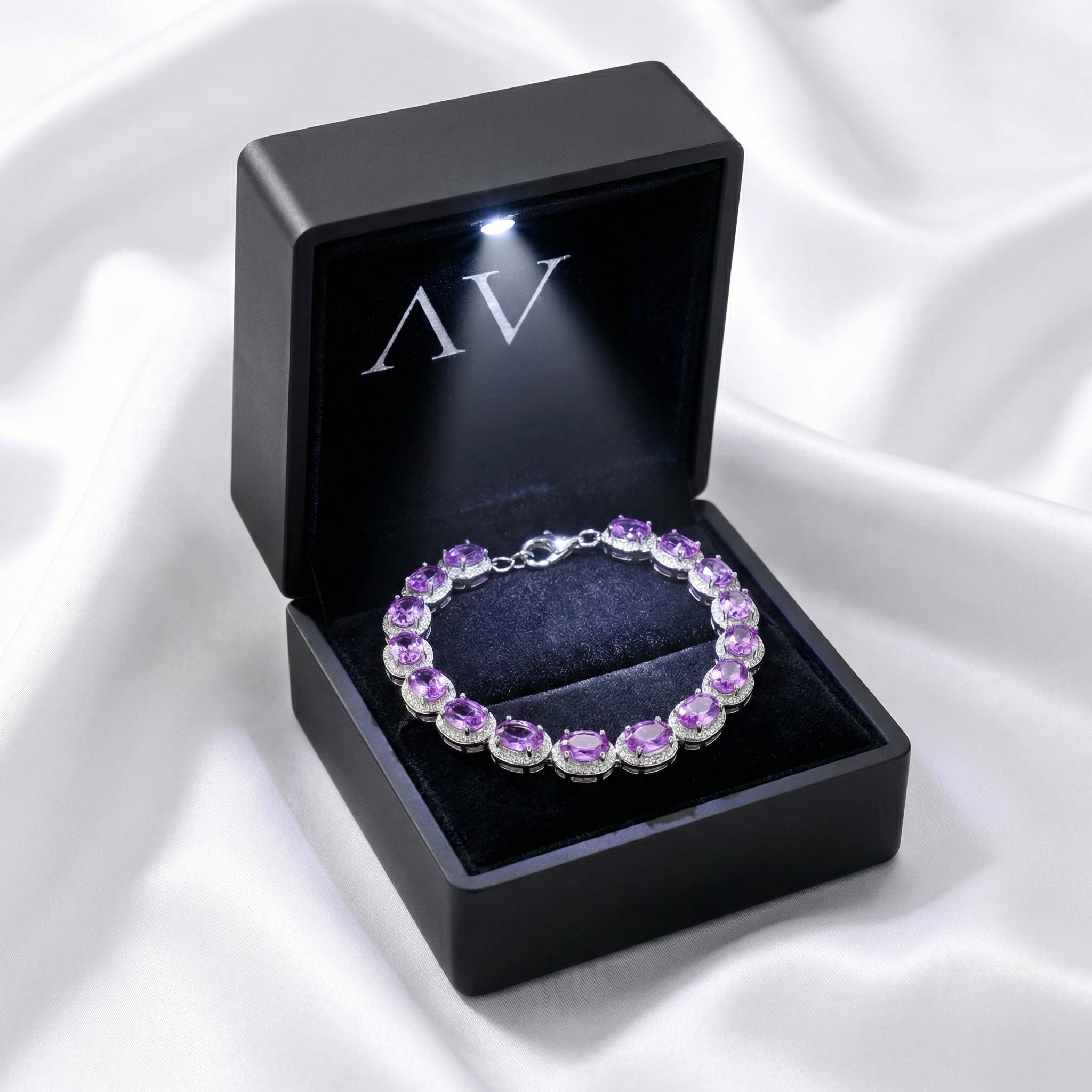 Simulated amethyst sterling silver bracelet inside a black LED-lighted jewelry gift box.