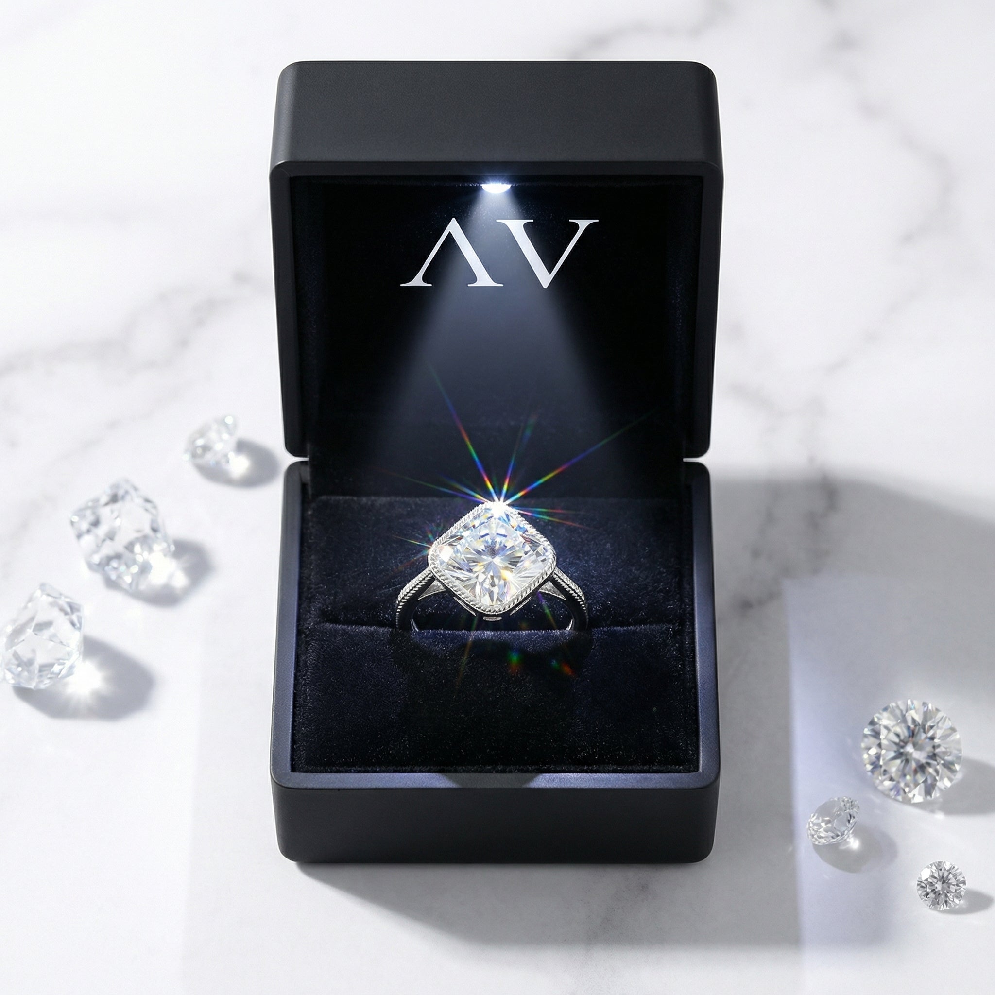 Cushion cut simulated diamond sterling silver ring inside a black LED-lit gift box on a marble background.