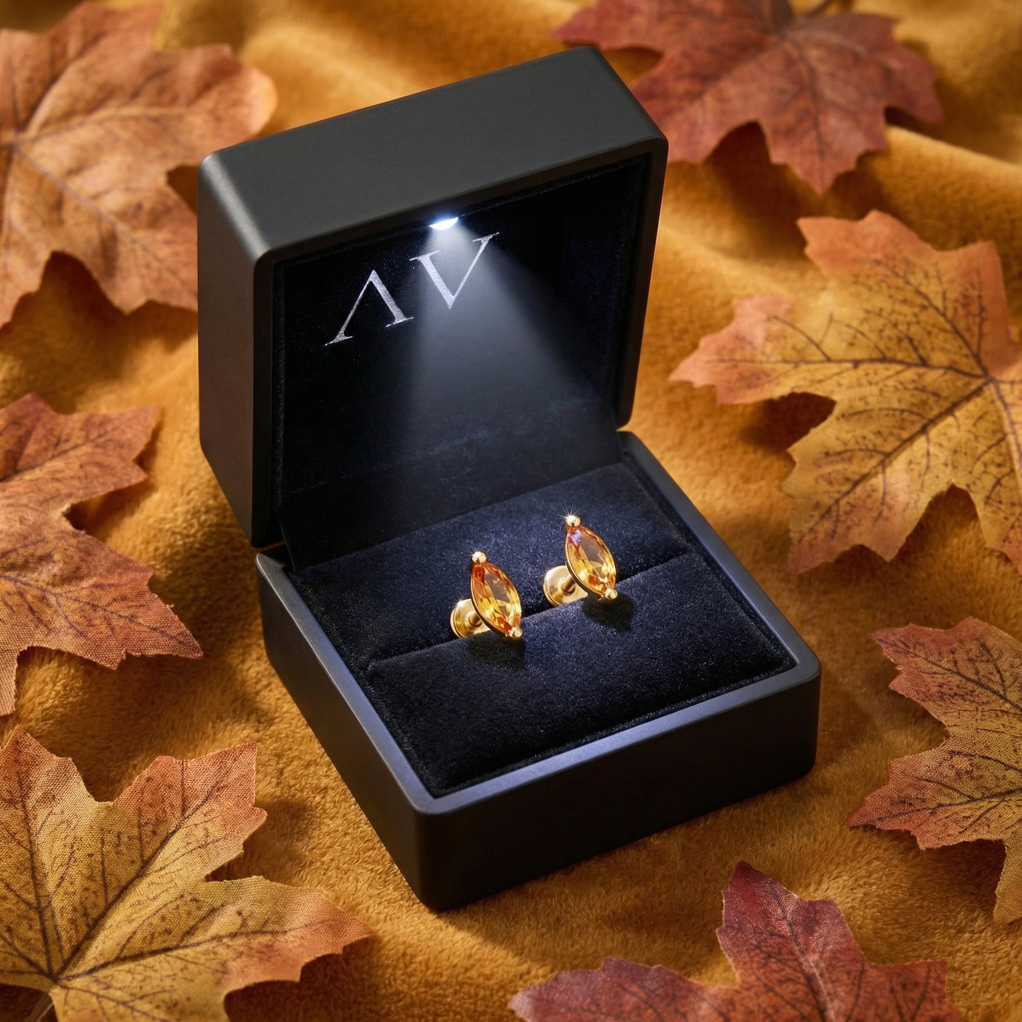 Marquise-cut simulated topaz earrings in 18K gold vermeil inside a black LED-lit jewelry gift box.