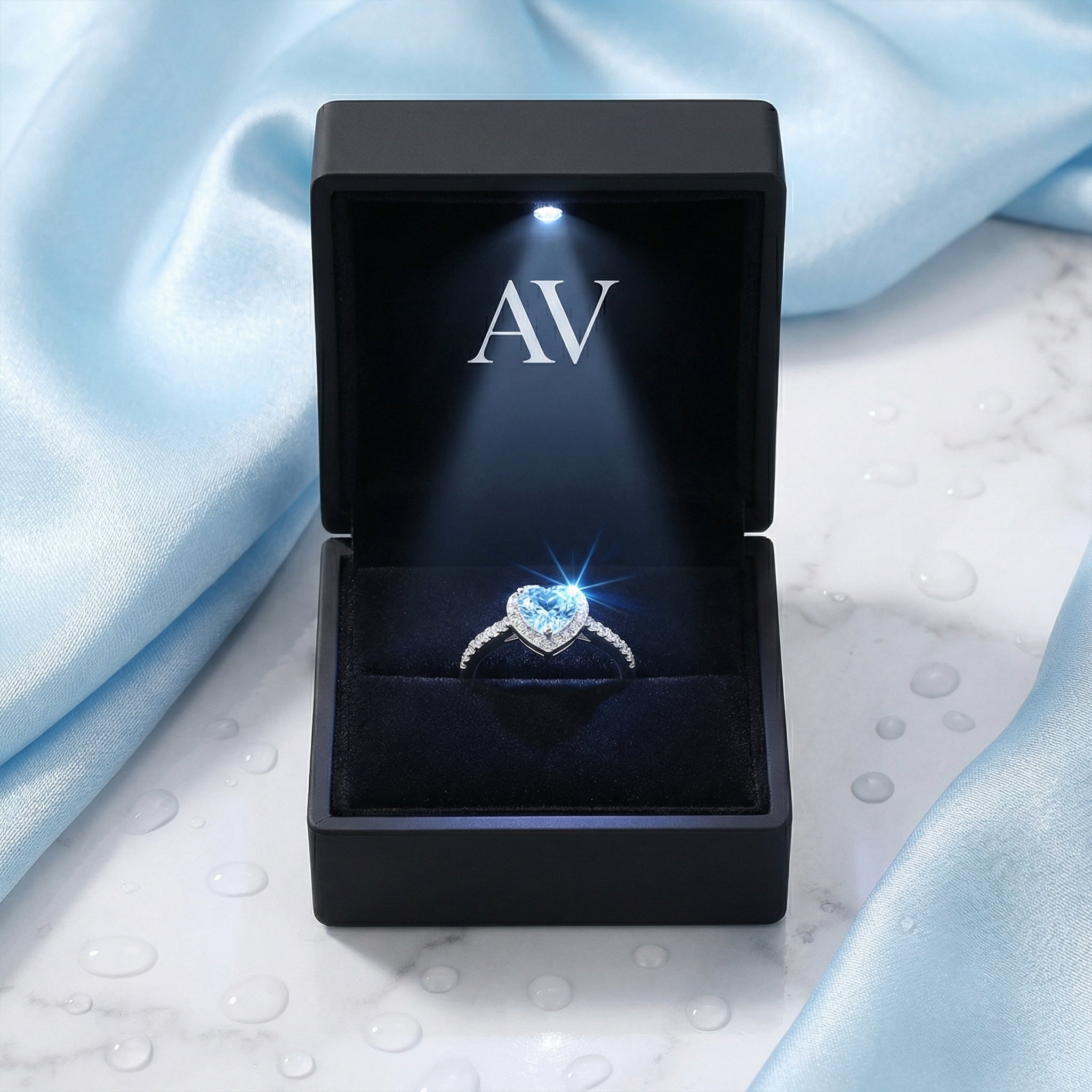 Sterling silver heart-cut simulated aquamarine ring in an open LED gift box on blue silk.