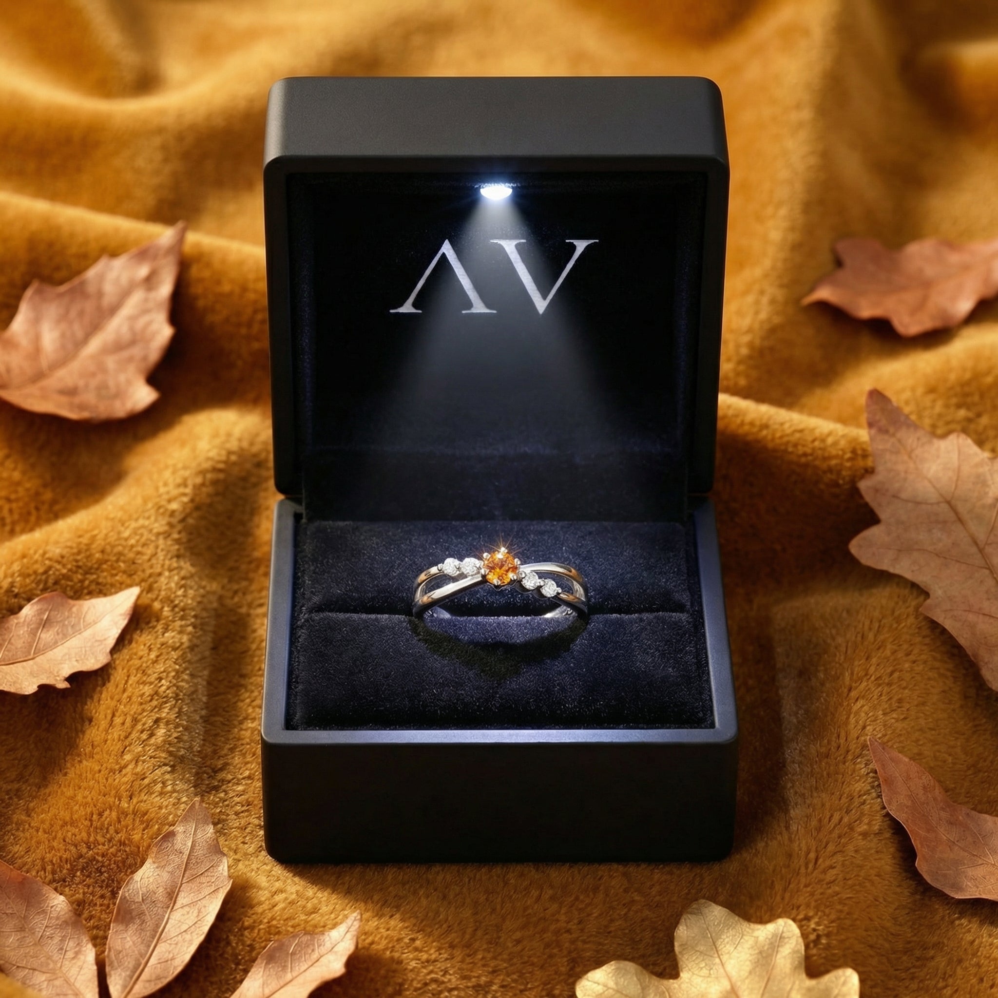 Sterling silver crossover ring with simulated topaz presented in a black lighted jewelry gift box.