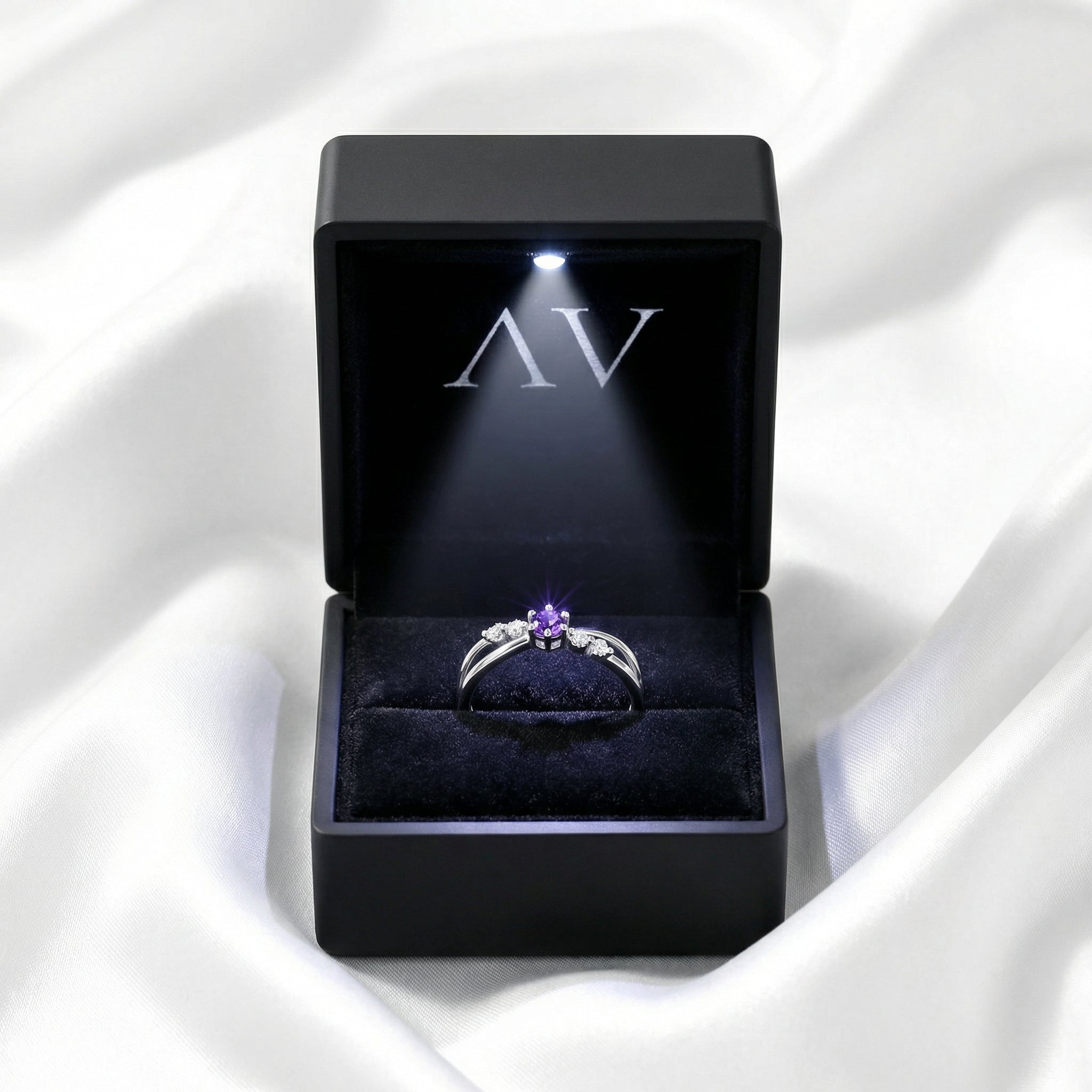 The Astraea sterling silver amethyst ring inside a black LED-lit jewelry gift box.