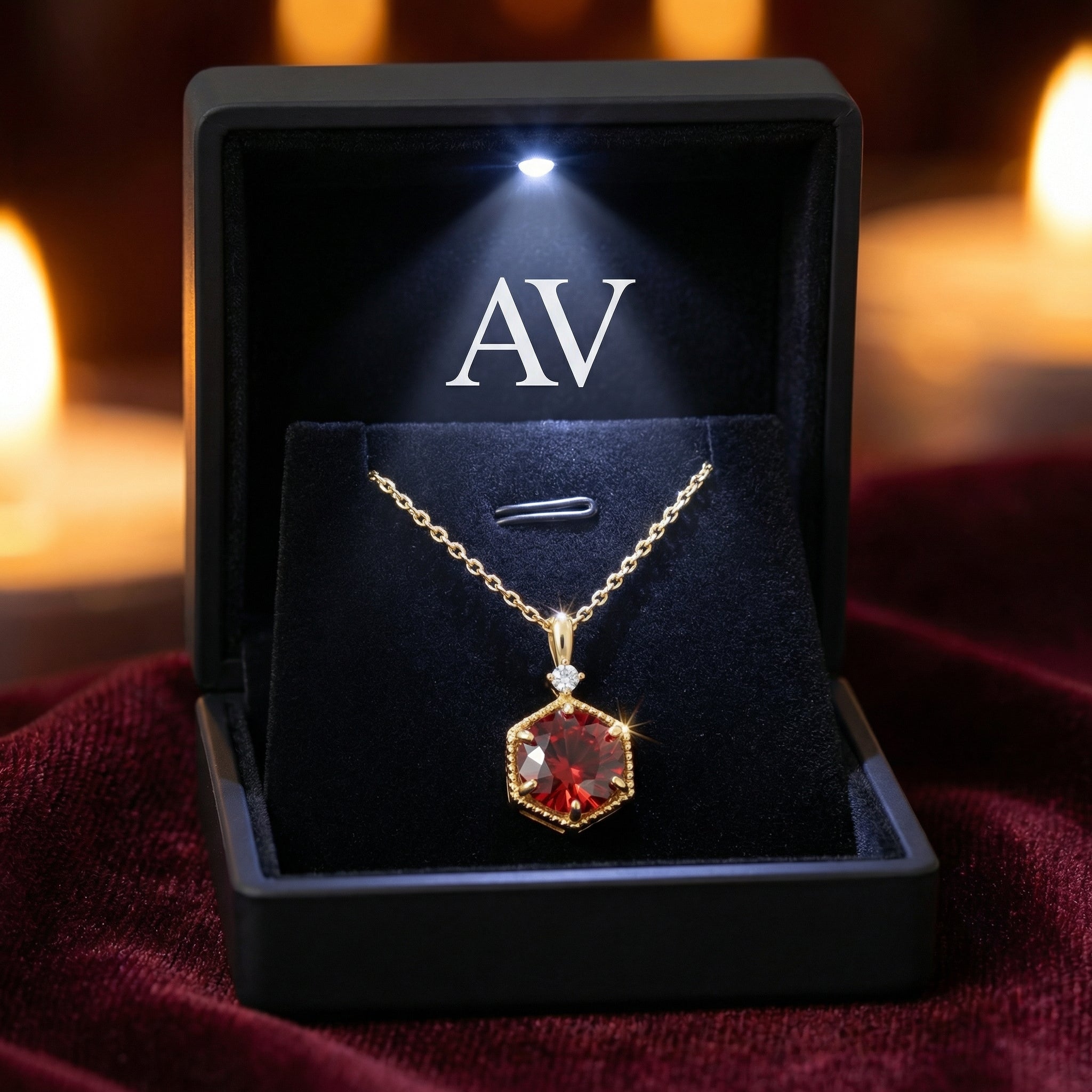 Kyra Hex 18K gold vermeil necklace with a red simulated garnet in a lighted black jewelry presentation box.