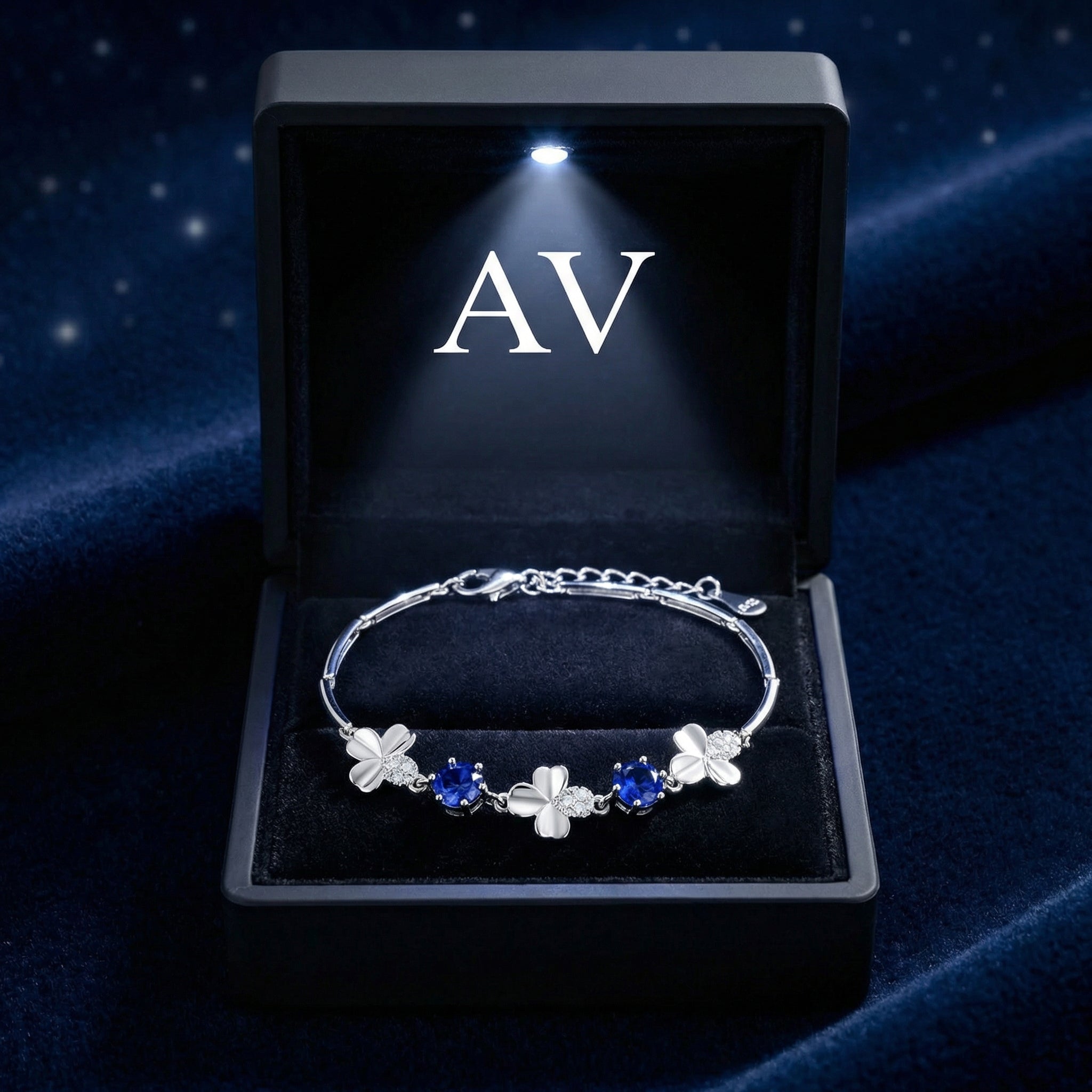 Sterling silver blue sapphire clover bracelet presented in a black lighted gift box with AV branding.