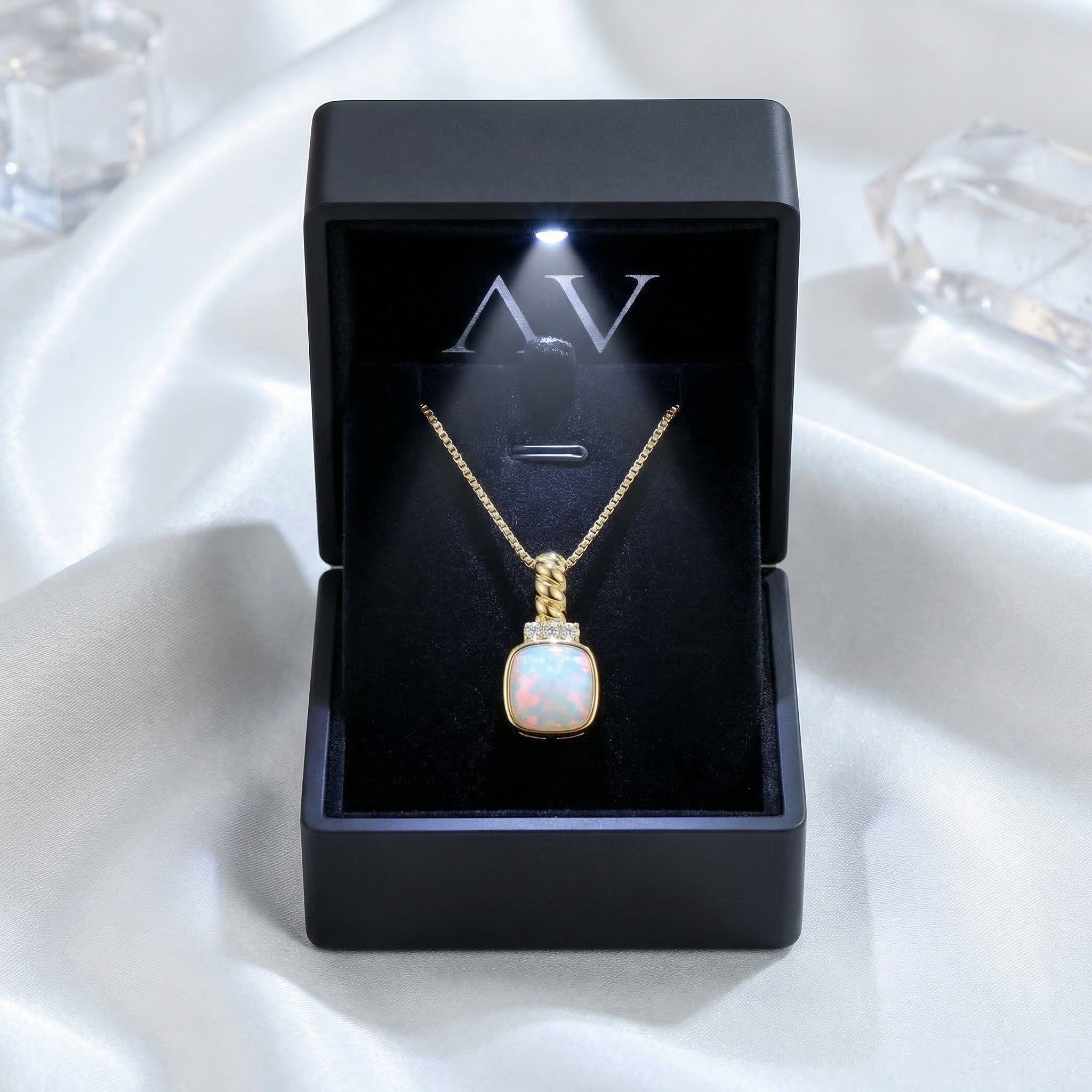 Gold-tone white opal cushion pendant necklace displayed in a black LED-lit jewelry gift box.