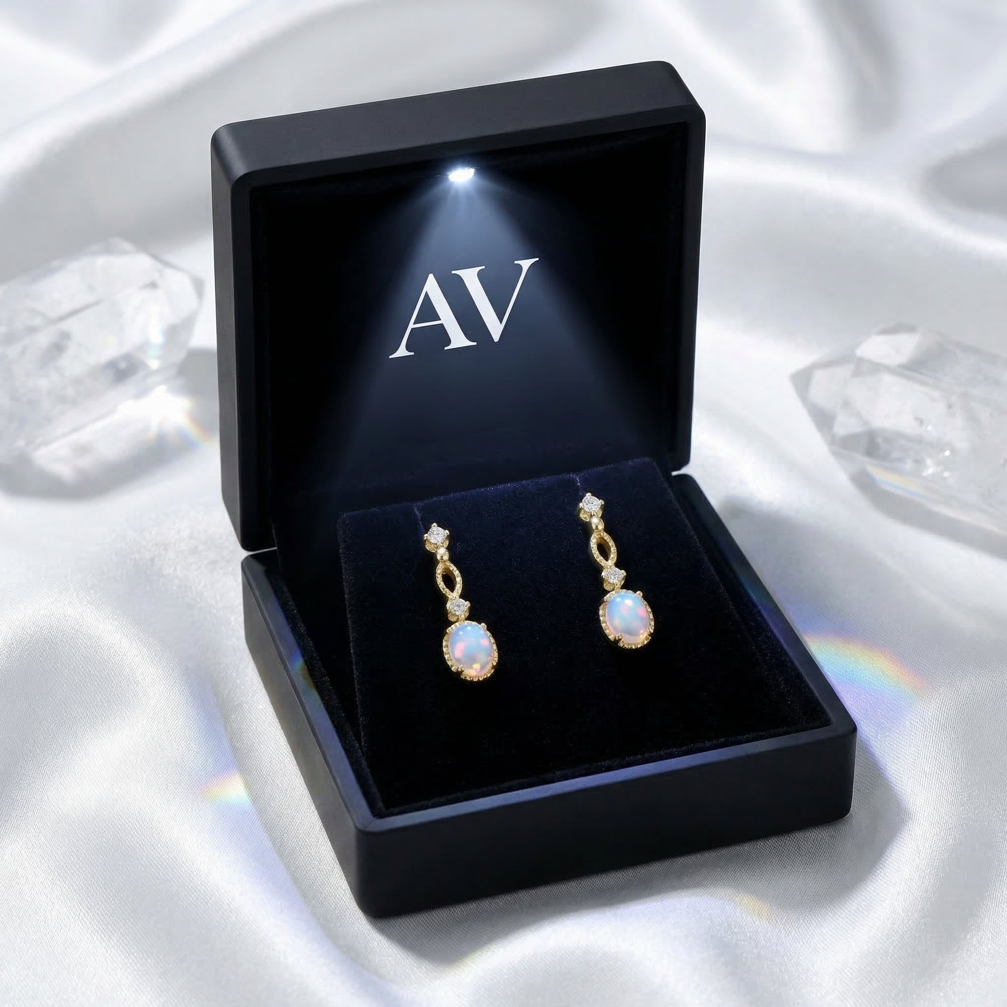Gold-tone Lorelei oval white opal earrings presented in a premium black LED-lit jewelry gift box.