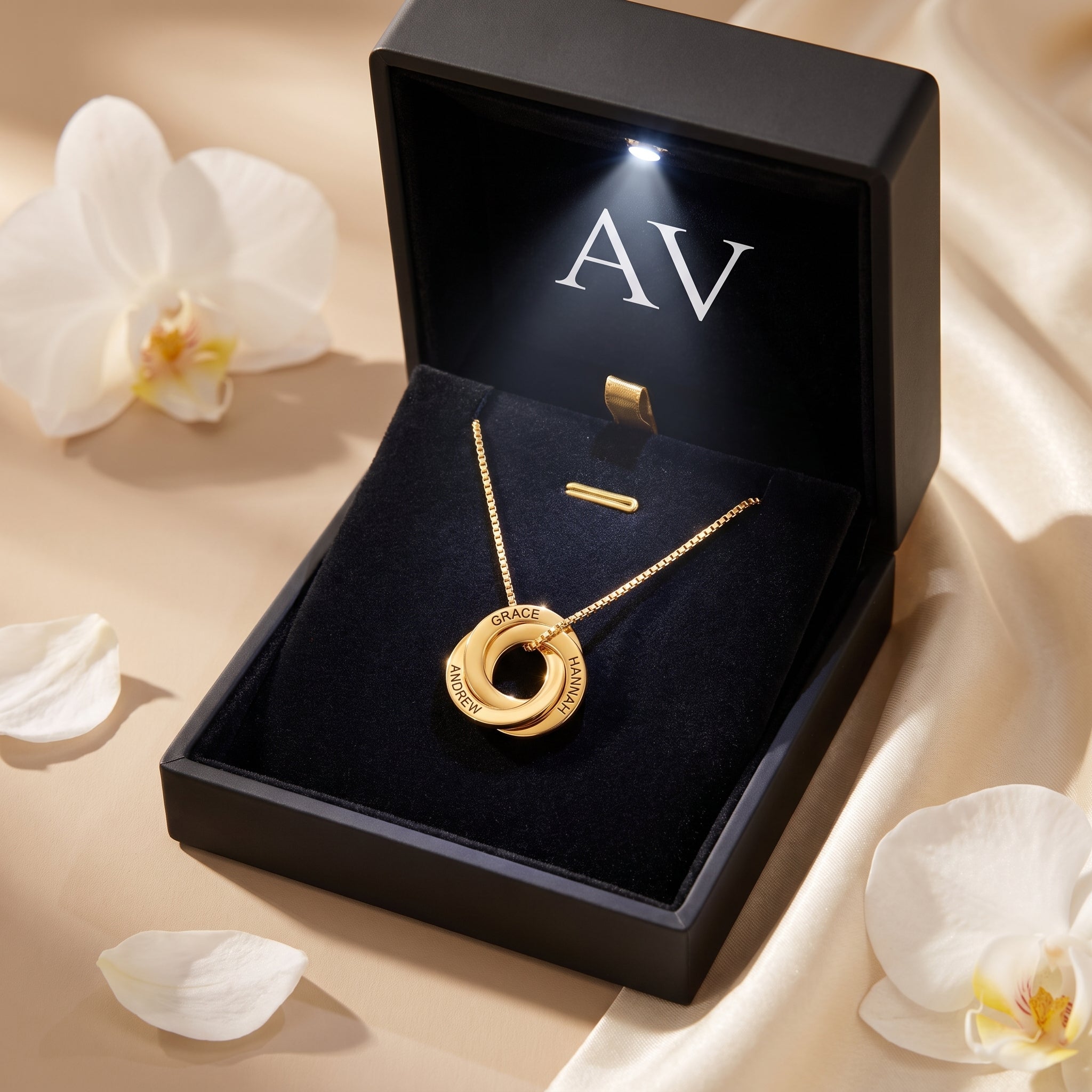 Gold Camilla necklace with three interlocked engraved rings in a lighted gift box.