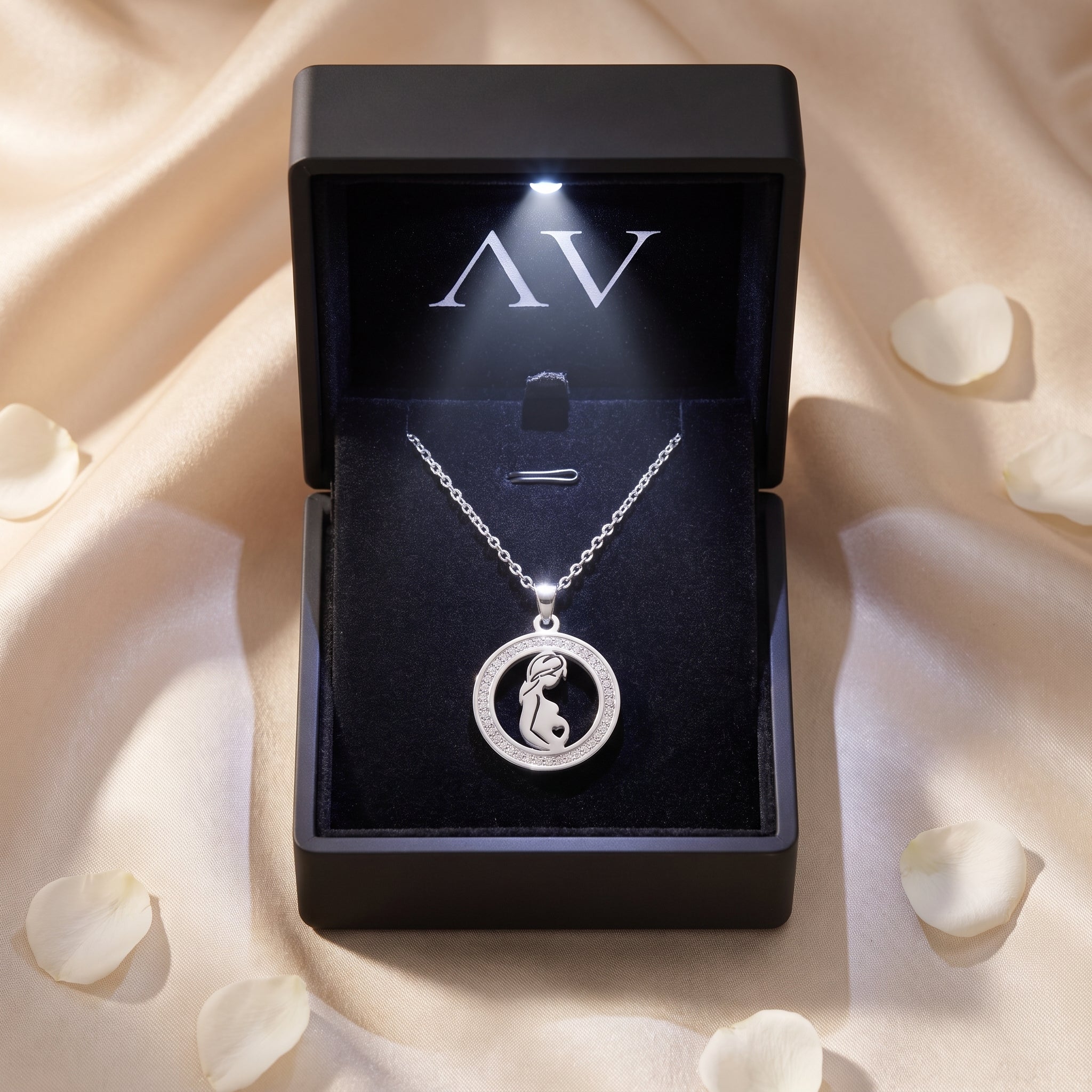 Silver Madrina necklace presented in a black LED-lit gift box on a satin background with petals.