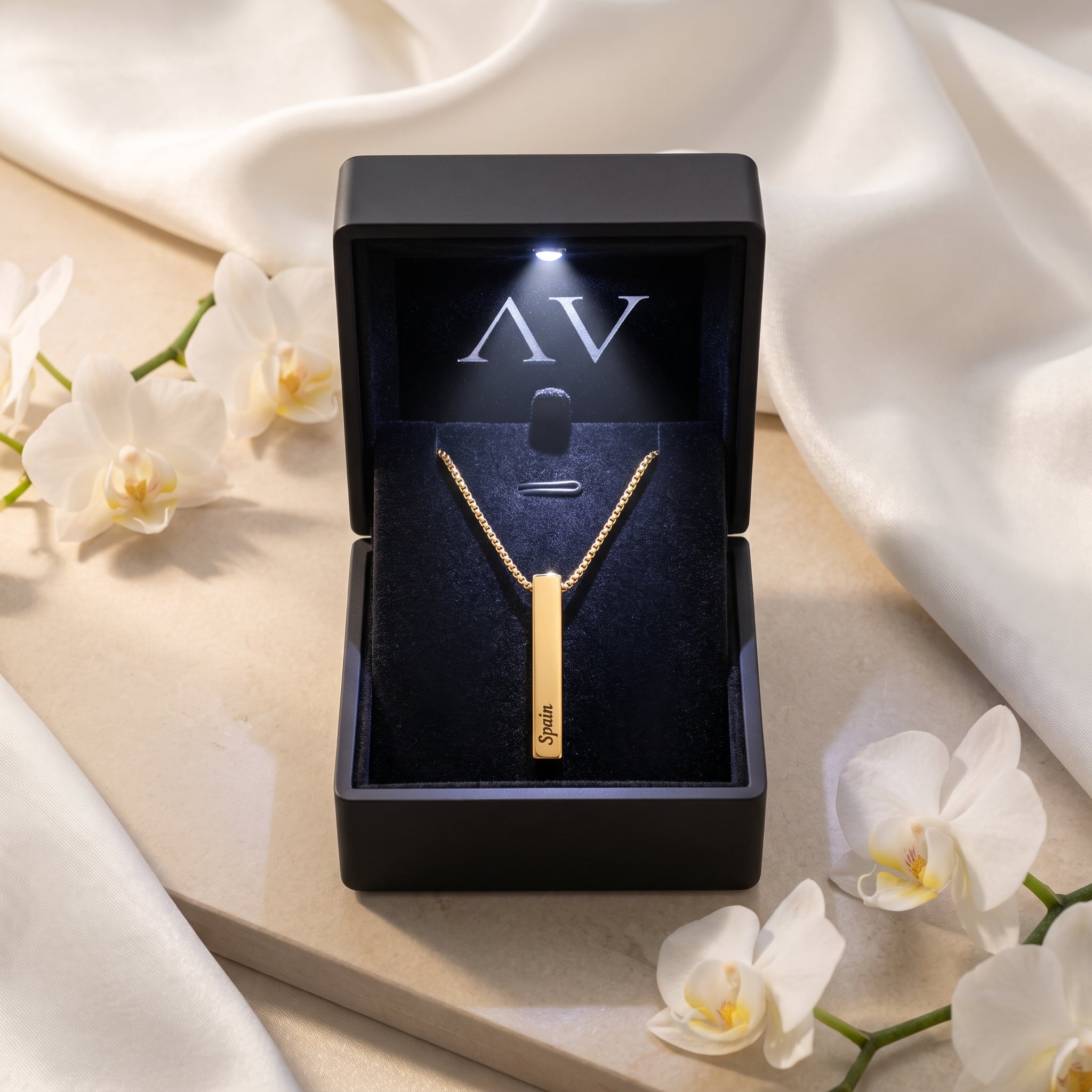 Gold bar necklace inside a black LED-lit presentation gift box.