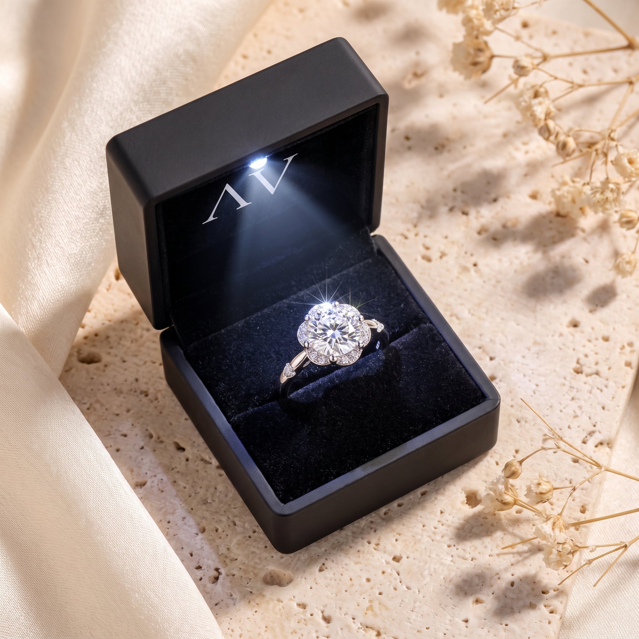 Round cubic zirconia silver ring inside a lighted black presentation box.