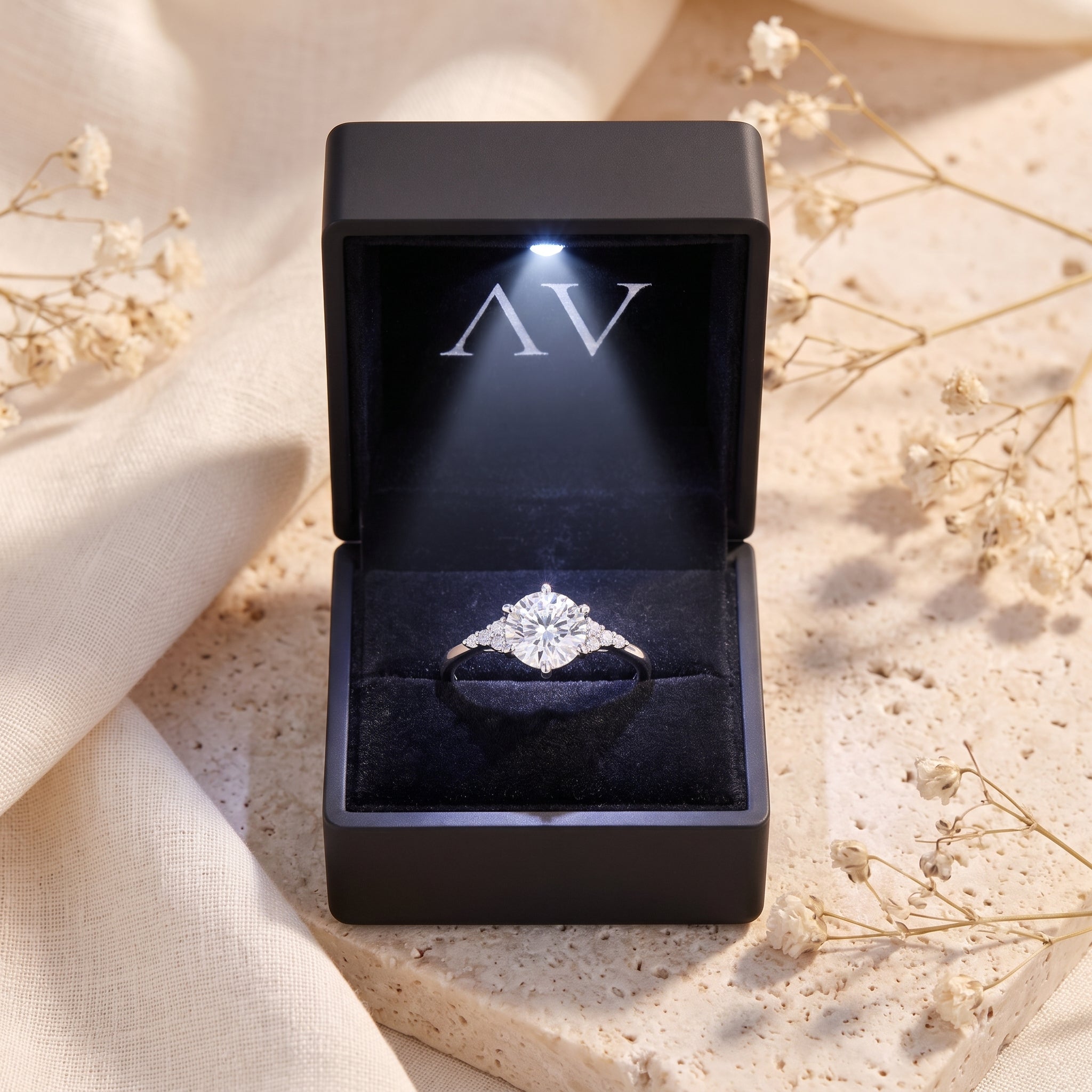 Sterling silver solitaire ring displayed in a black lighted presentation box.