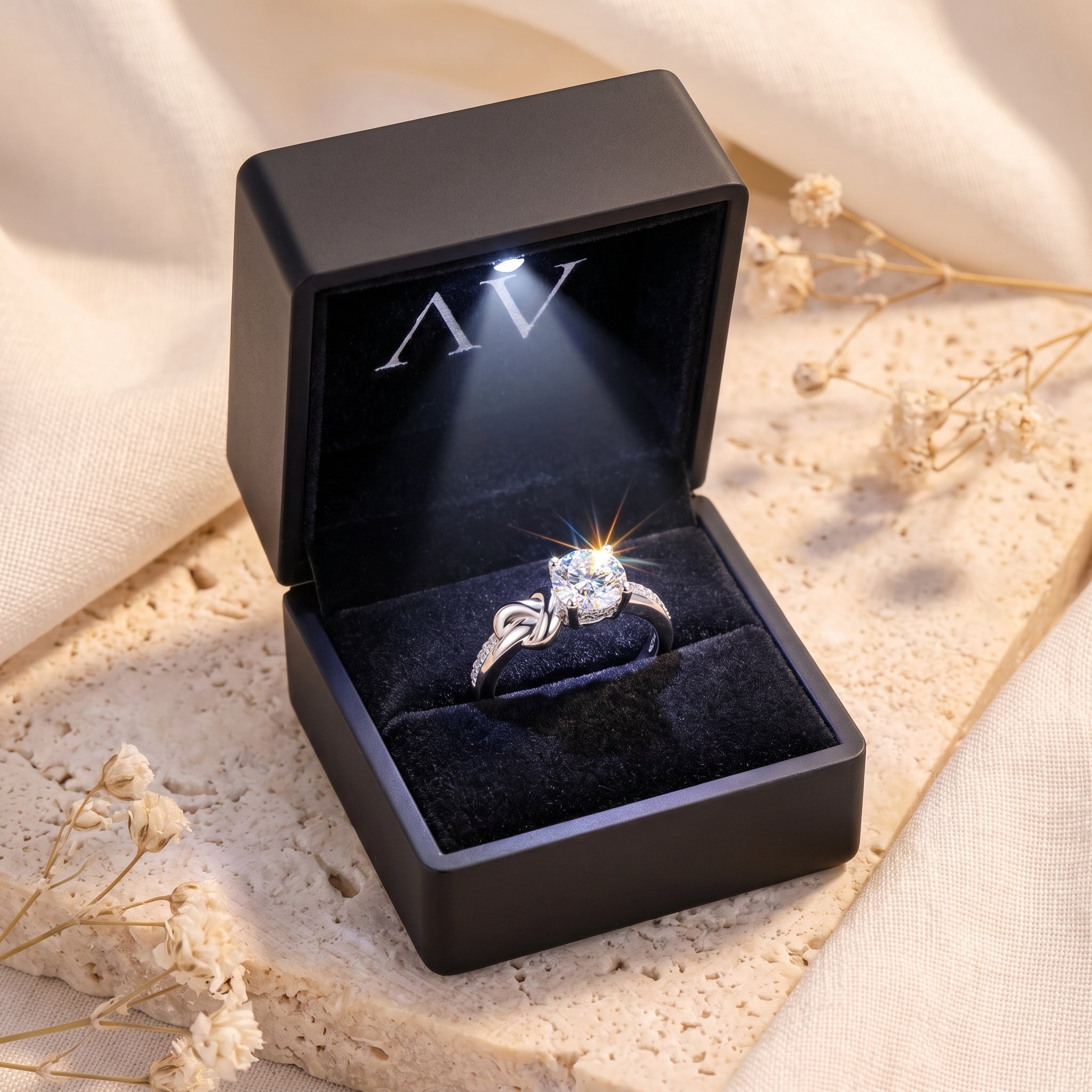 Silver devotion knot solitaire ring presented in a lighted black jewelry gift box.