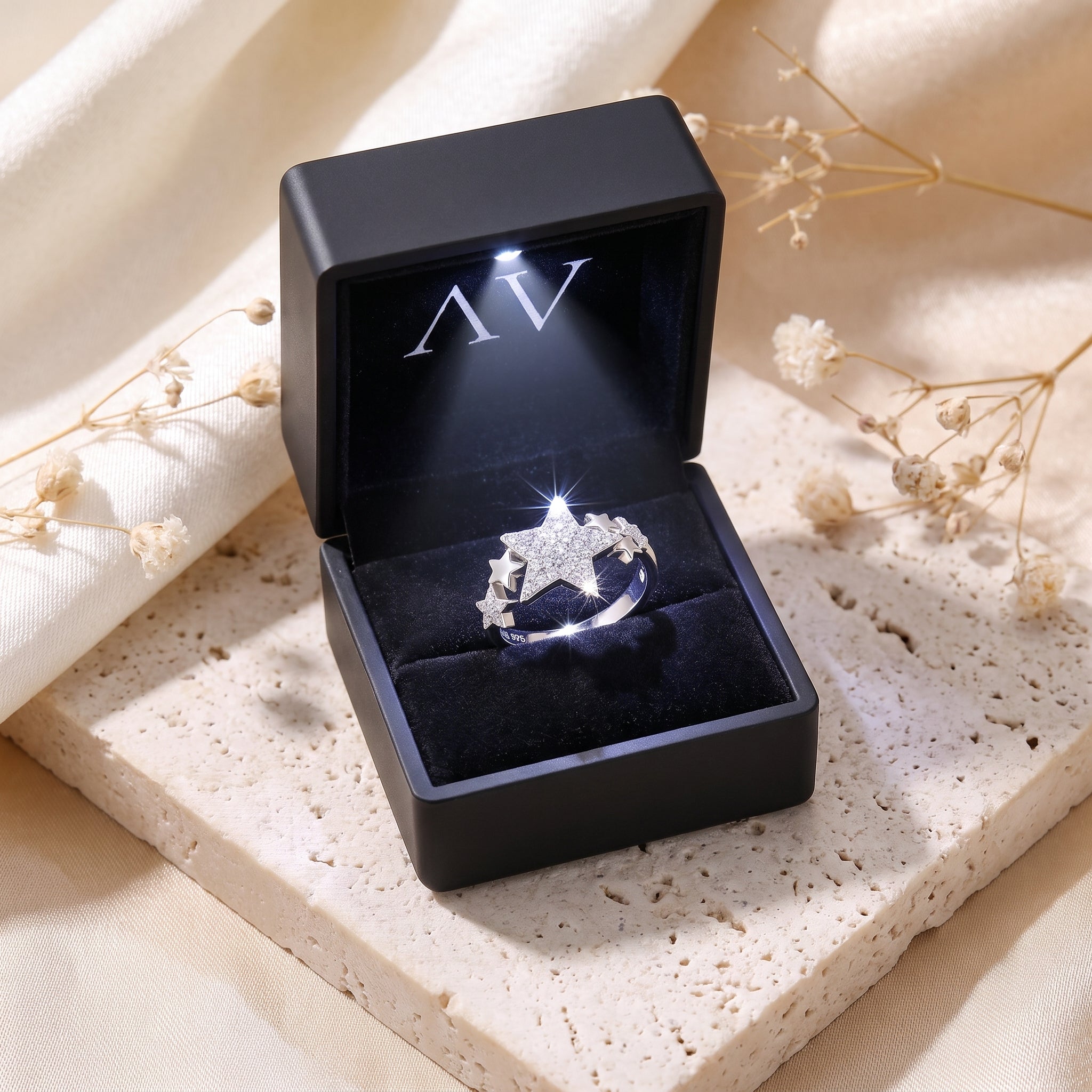 Silver star cluster promise ring displayed in a black LED-lit jewelry gift box.