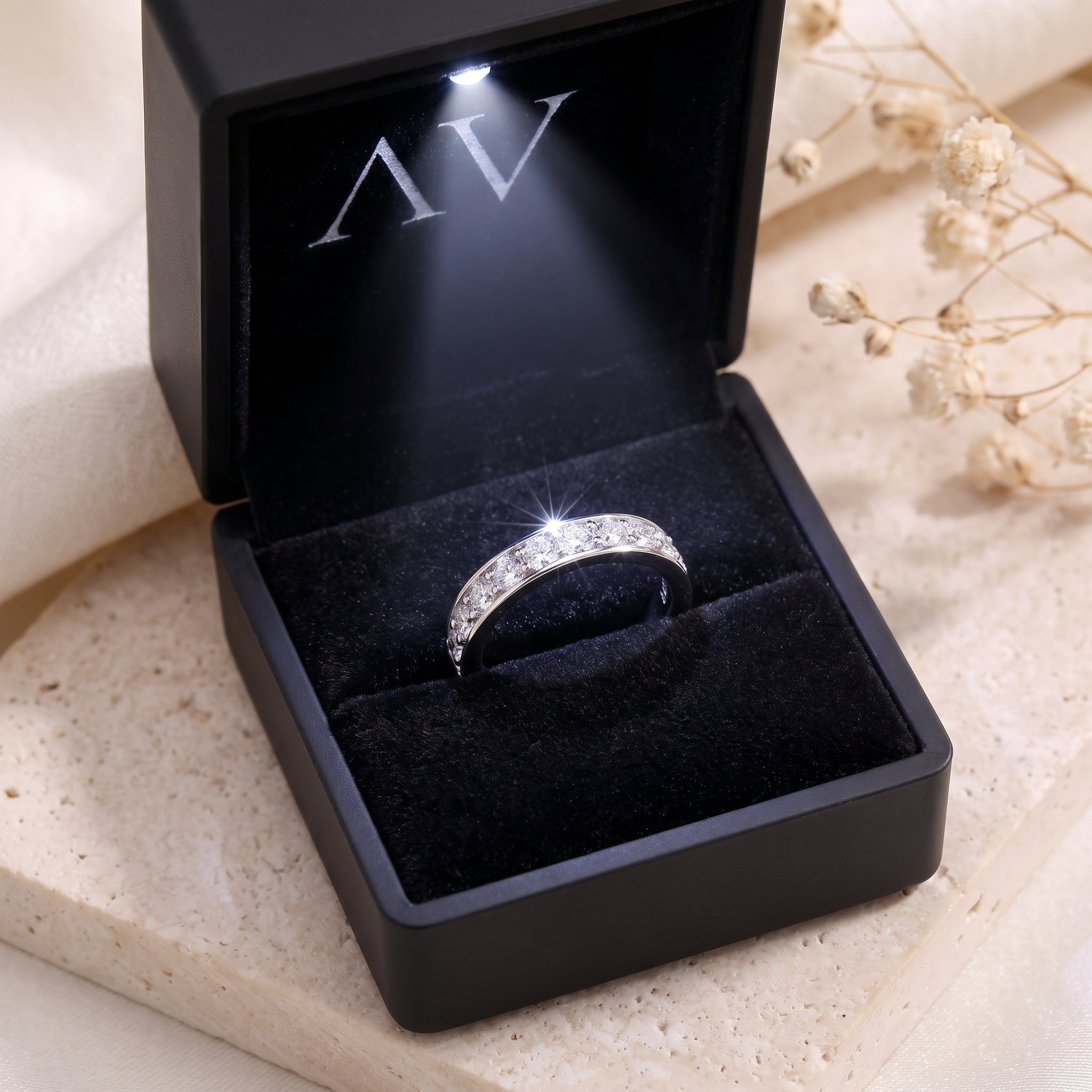 Silver cubic zirconia eternity ring in a black LED-lit gift box.