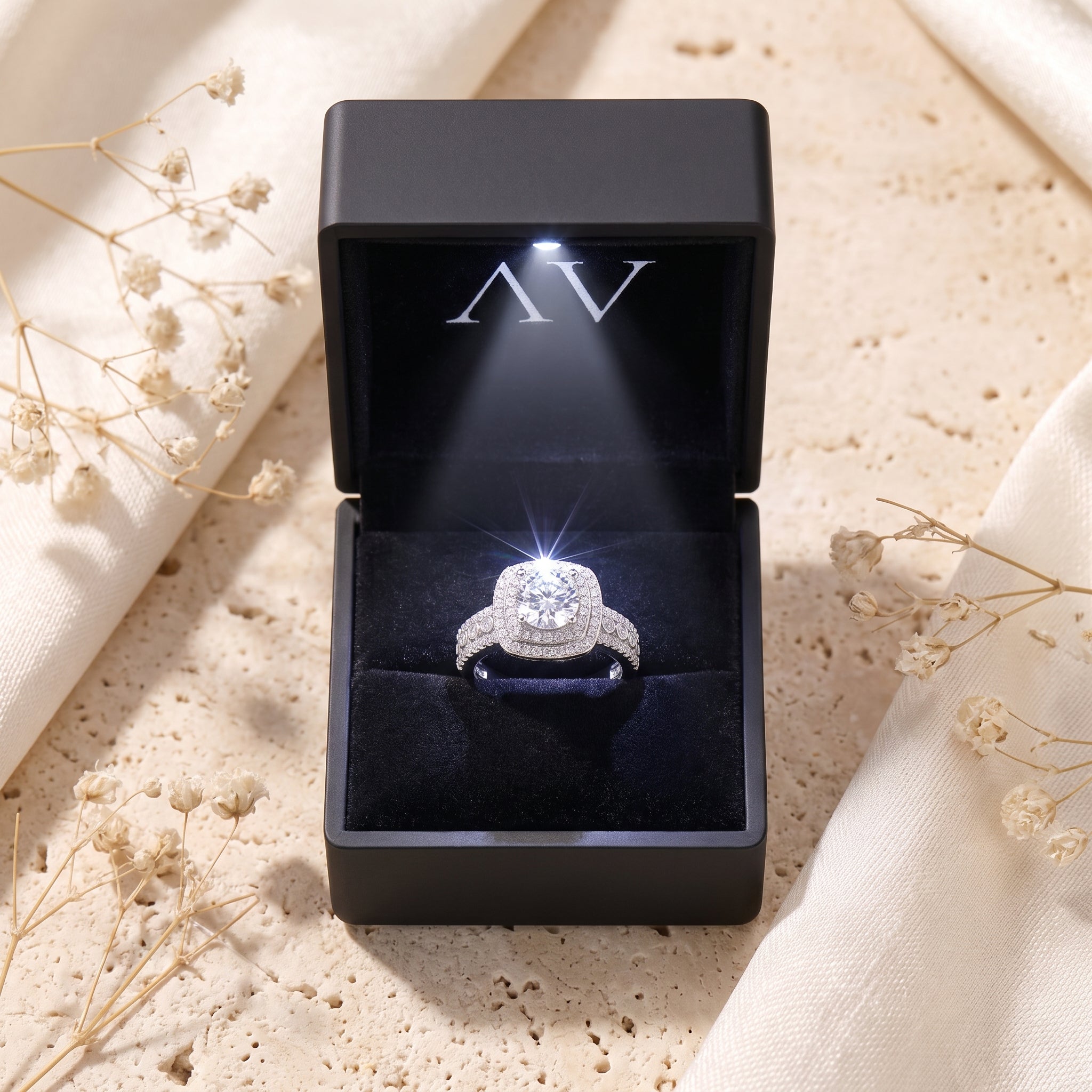 Silver cushion double halo ring displayed inside a black LED-lit presentation gift box.